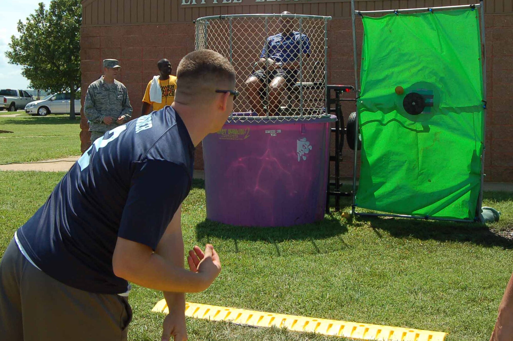 Staff Sgt. Stephen McKinley, 633rd Logistics Readiness Squadron vehicle operations dispatcher, attempts to dunk Colonel Reggie Austin, 633rd Air Base Wing vice-commander, during Junior Enlisted Appreciation Day at Langley Air Force Base, Va., July 15, 2011.  Wing members voted for dunking candidates, and leaders who were “elected”reported to the dunking booth to be repeatedly submerged by a throw of a softball.  JEAD is an annual event providing food, games, activities and prizes for hardworking junior enlisted members in the grades of E-6 and below.  (U.S. Air Force photo by Senior Master Sgt. Anna Hayman/Released) 


