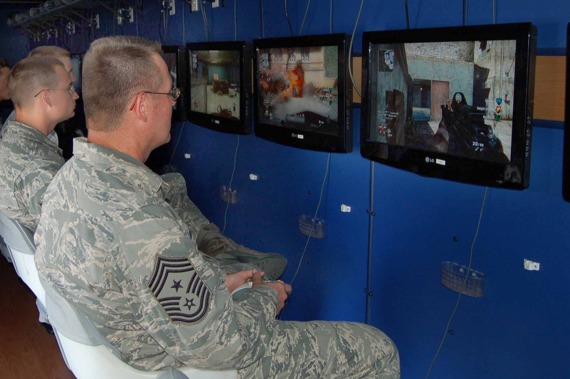 Chief Master Sgt. Kevin Howell, 633rd Air Base Wing command chief master sergeant, joins junior enlisted members in a round of virtual combat in the Game Bus, a mobile video gaming theatre, during Junior Enlisted Appreciation Day at Langley Air Force Base, Va., July 15, 2011.  A variety of base agencies and organizations sponsored the event, which included free food, games, activities and prizes for enlisted members in the grades of E-6 and below and their families. (U.S. Air Force photo by Senior Master Sgt. Anna Hayman/Released) 