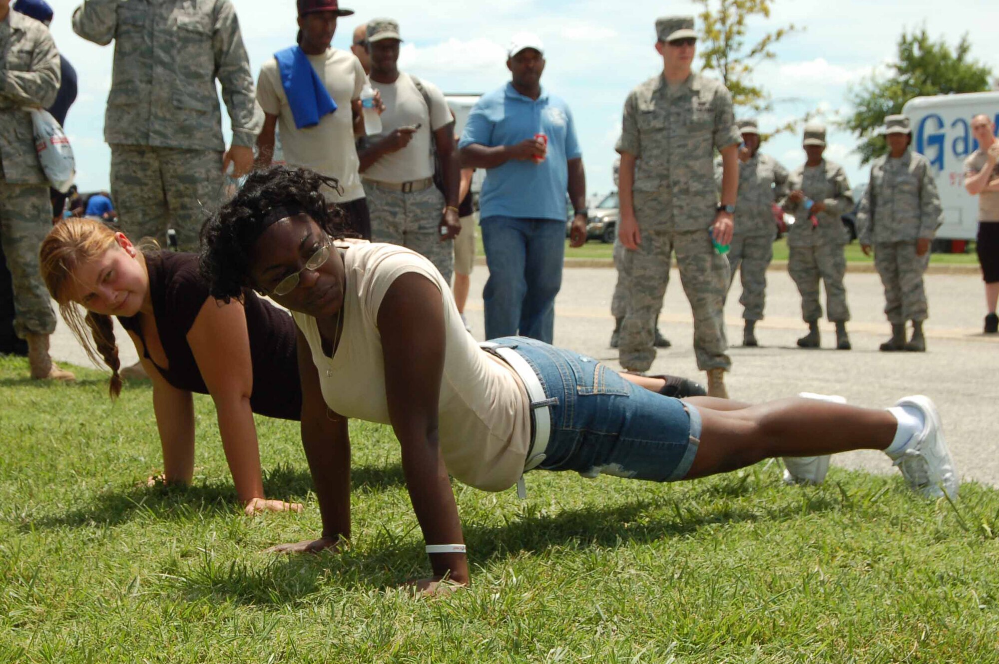 Airman 1st Class Jessica Walker, 633rd Communication Squadron, and Airman 1st Class Kimara Duncan, 94th Aircraft Maintenance Unit crew chief, struggle to remain in the “up” push-up position for as long as possible during  a competition at Junior Enlisted Appreciation Day at Langley Air Force Base, Va., July 15, 2011.   Airman Walker and Airman 1st Class Monroe McAnuff, 1st Maintenance Squadron, persevered and were each awarded an Air Force physical training uniform.  (U.S. Air Force photo by Senior Master Sgt. Anna Hayman/Released)