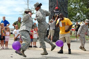 Cheered by onlookers, Staff Sgt Maura Johnson, 1st Maintenance Operations Squadron maintenance training instructor, battles it out with Airman 1st Class Brittany Blake, 633rd Medical Operations Squadron aerospace medical technician, in the balloon stomping game, a fun competition held during Junior Enlisted Appreciation Day at Langley Air Force Base, Va., July 15, 2011.  Thirty people tied balloons to their ankles and tried desperately to pop one another’s balloons for a prize.  Sergeant Johnson and Airman Blake were the final contenders, with Airman Blake eventually triumphing.  Many such activities were included in JEAD, held each year to thank members in the grades of E-6 and below for their efforts in mission accomplishment.   (U.S. Air Force photo by Senior Master Sgt. Anna Hayman/Released) 