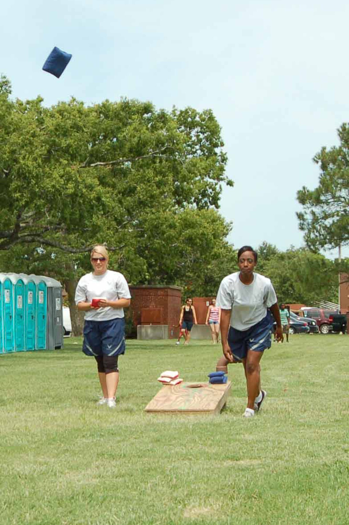 Airman Ivy Carrier, 439th Supply Chain Operations Squadron bomber stock control apprentice, watches her teammate, Airman 1st Class Angelica,439 SCOS, hurl a beanbag during a cornhole game during Junior Enlisted Appreciation Day at Langley Air Force Base, Va., July 15, 2011.  The game was played by junior enlisted members in the grades of E-6 and below during a day-long event held by the base to reward their hard work throughout the year.   (U.S. Air Force photo by Senior Master Sgt. Anna Hayman/Released)