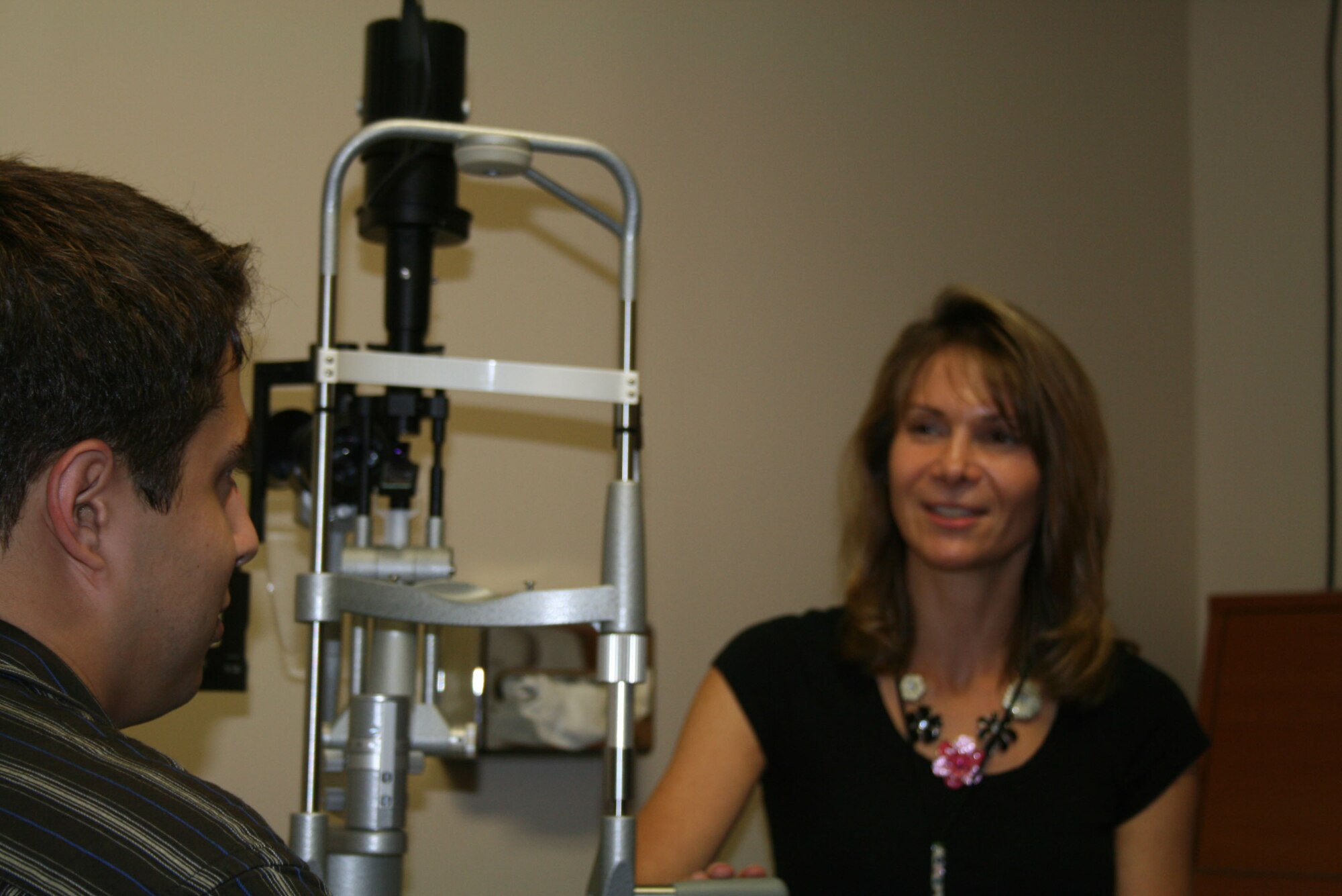 Dr. Elena Llewellyn, an optometrist at Langley Air Force Base, Va., consults a client during a check-up July 14. Llewellyn adivsed her patient of the dangers and implications of sun exposure and recommended wearing sunglasses during the intense summer months. (U.S. Air Force photo by Connor Burne)