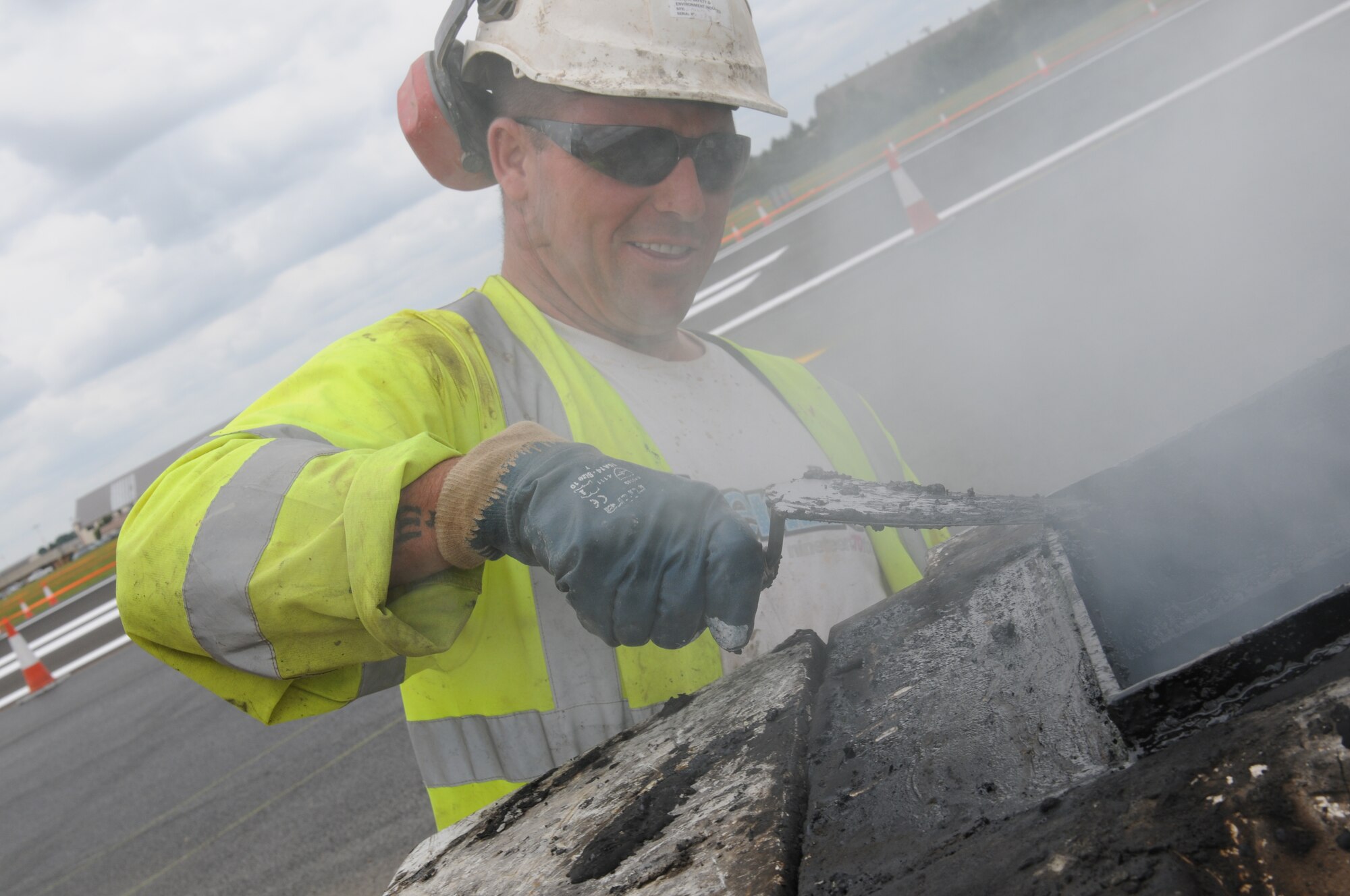 ROYAL AIR FORCE LAKENHEATH, England - Ray Bundy, Allied Drilling construction worker, tests the consistency of a tar mixture on the flight line on July 14, 2011. The runway closure was part of a three year plan to renovate the entire flightline. It was completed on July 18, 2011. The jets were stationed at RAF Mildenhall for 17 days during the last phase.  (U.S. Air Force photo/Airman Cory Payne)