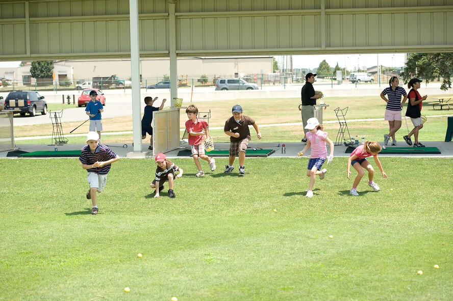 Children from the First Tee of Delaware golf program rush onto the Eagle Creek Golf Course driving range to collect golf balls July 13, 2011, at Dover Air Force Base, Del. The First Tee of Delaware is a program for children and teenagers from kindergarten to 12th grade to teach the etiquette and skills of golf. (U.S. Air Force photo by Airman 1st Class Jacob Morgan)