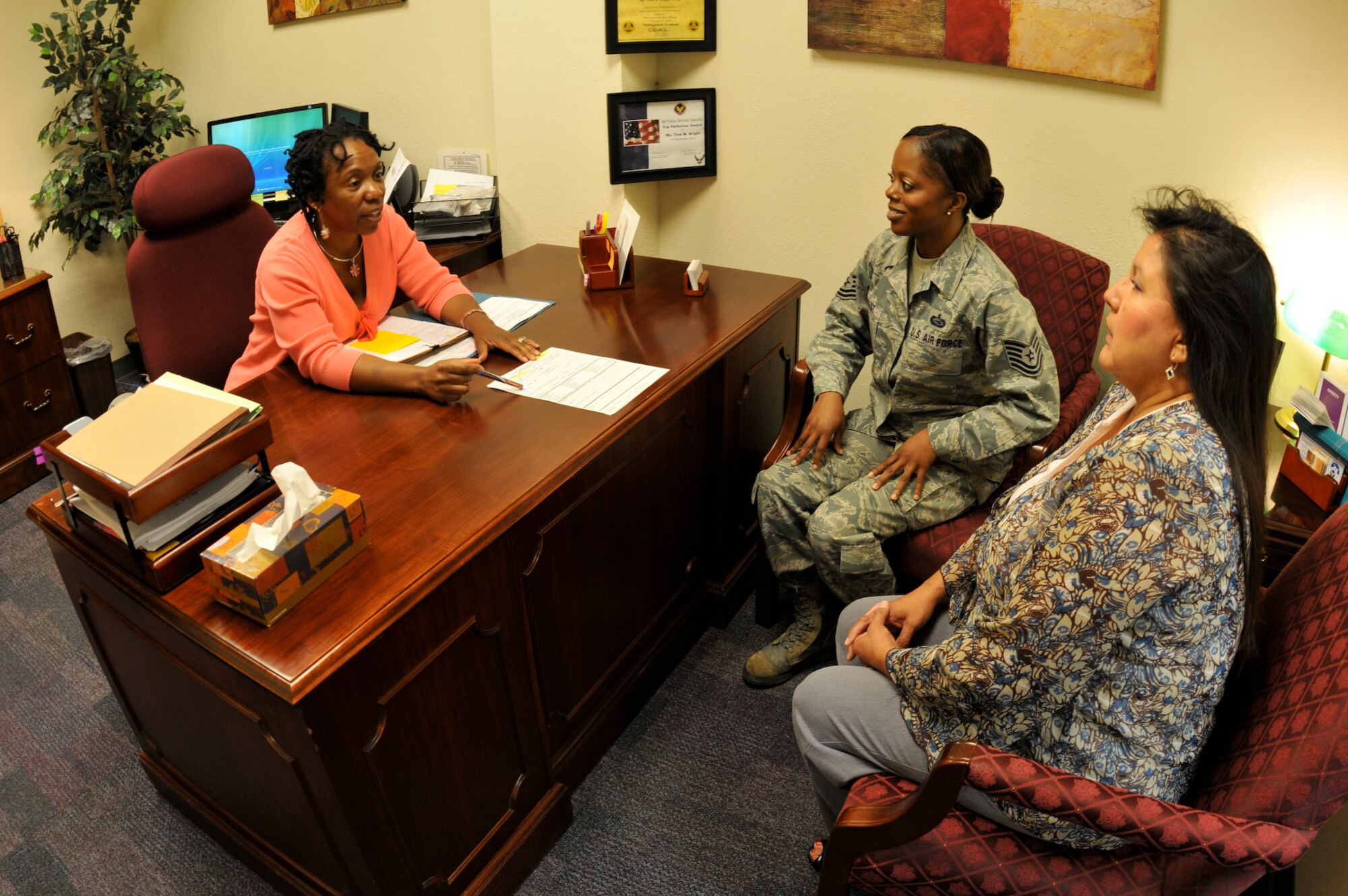 Equal opportunity specialists Tina Marie Brighton, Master Sgt. Delana August and Donna Rocha discuss an EO case. The EO office received an Air Force-wide award for excellence last month. (Air Force photo by Brian Schroeder)