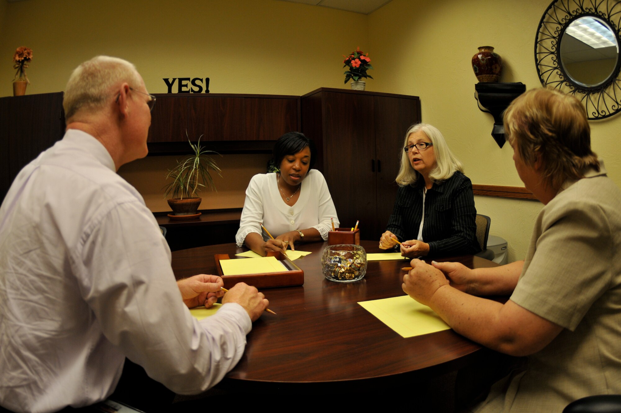 Alternative Dispute Resolution mediators Angela Parmer (left center) and Jane Kuehnert (right center) discuss a case with clients during a mediation session. ADR mediation is designed to resolve disputes between a complainant and respondent without filing a formal complaint. (Air Force photo by Brian Schroeder)