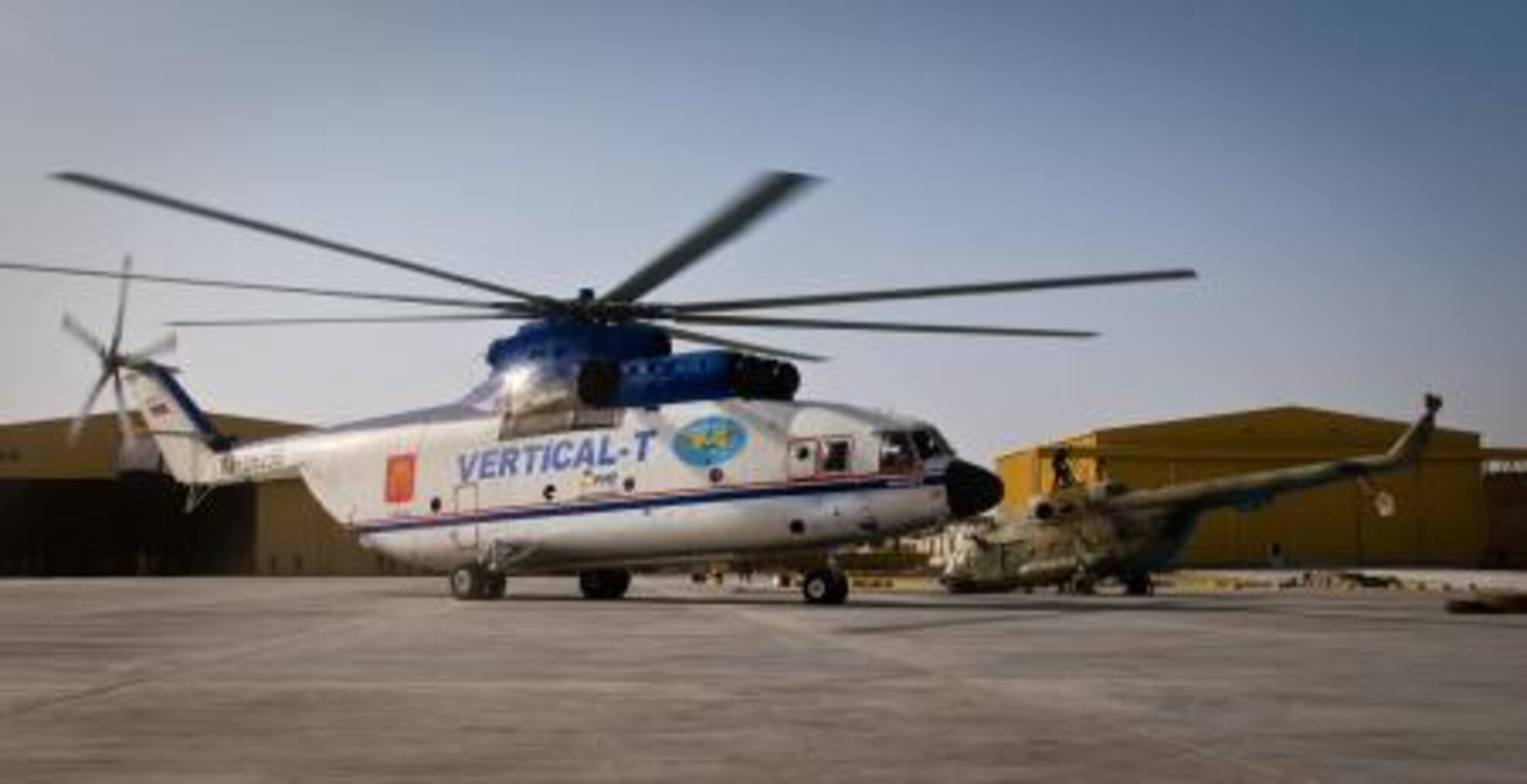 A Russian Mi-26 Halo helicopter sits next to a damaged Afghan Mi- 17 Hip helicopter it airlifted onto the Afghan Air Force flight line at Kandahar Airfield, Kandahar, Afghanistan, July 13, 2011. The Halo is more than 25 feet tall and more than 130 feet long.  The 738th Air Expeditionary Advisory Group provided assistance in using the ramp for temporary storage.  The aircraft was then transported to Kabul for repair.  (U.S. Army photo by Sgt. Edward Garibay)