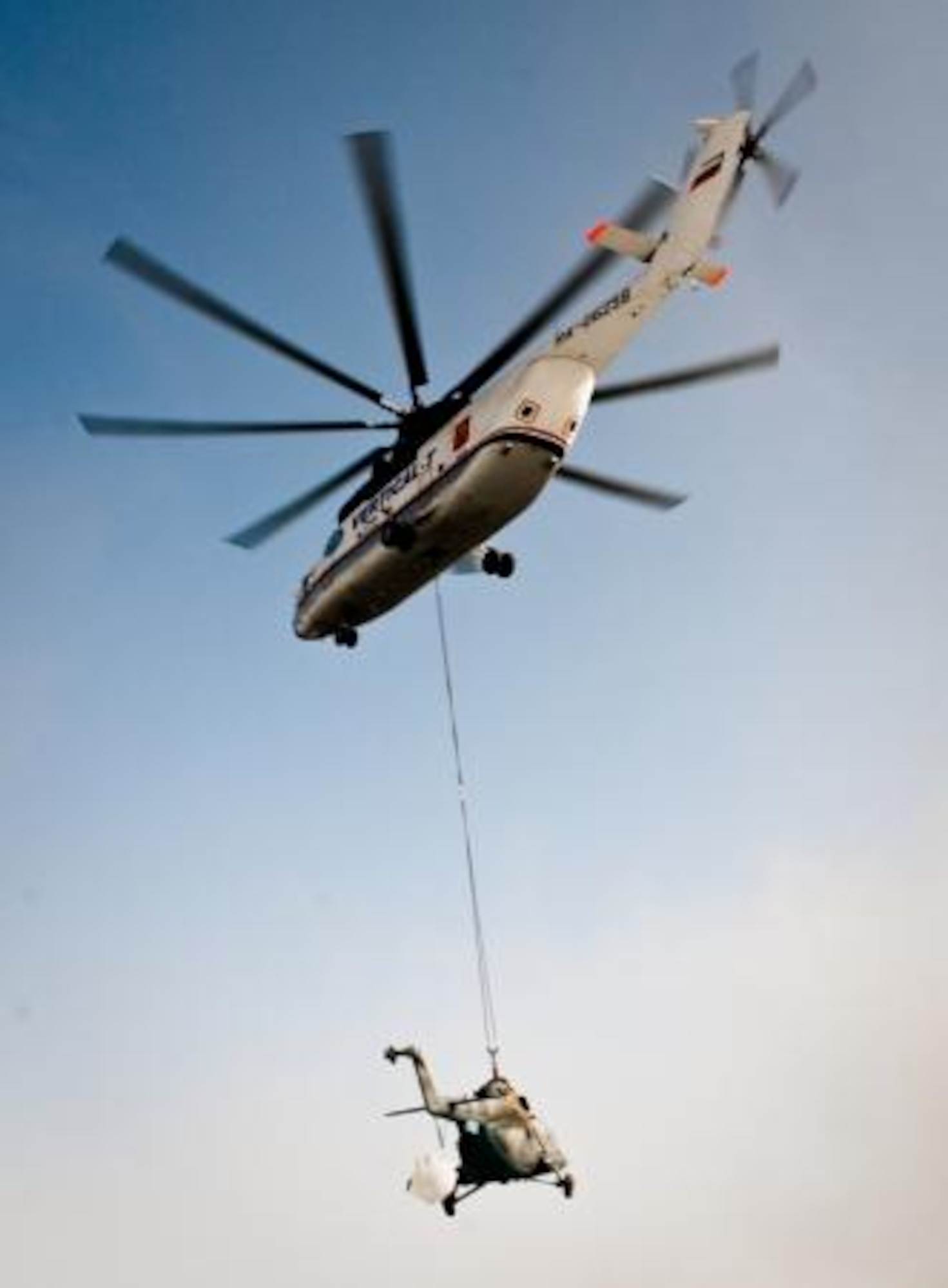A Russian Mi-26 Halo helicopter airlifts a damaged Afghan Mi- 17 Hip helicopter to the Afghan Air Force flight line at Kandahar Airfield, Kandhar, Afghanistan, July 13, 2011. The Halo has the capacity to transport approximately 100 troops or 45,000 lbs.  The 738th Air Expeditionary Advisory Group provided assistance in using the ramp for temporary storage.  The aircraft was then transported to Kabul for repair.  (U.S. Army photo by Sgt. Edward Garibay)