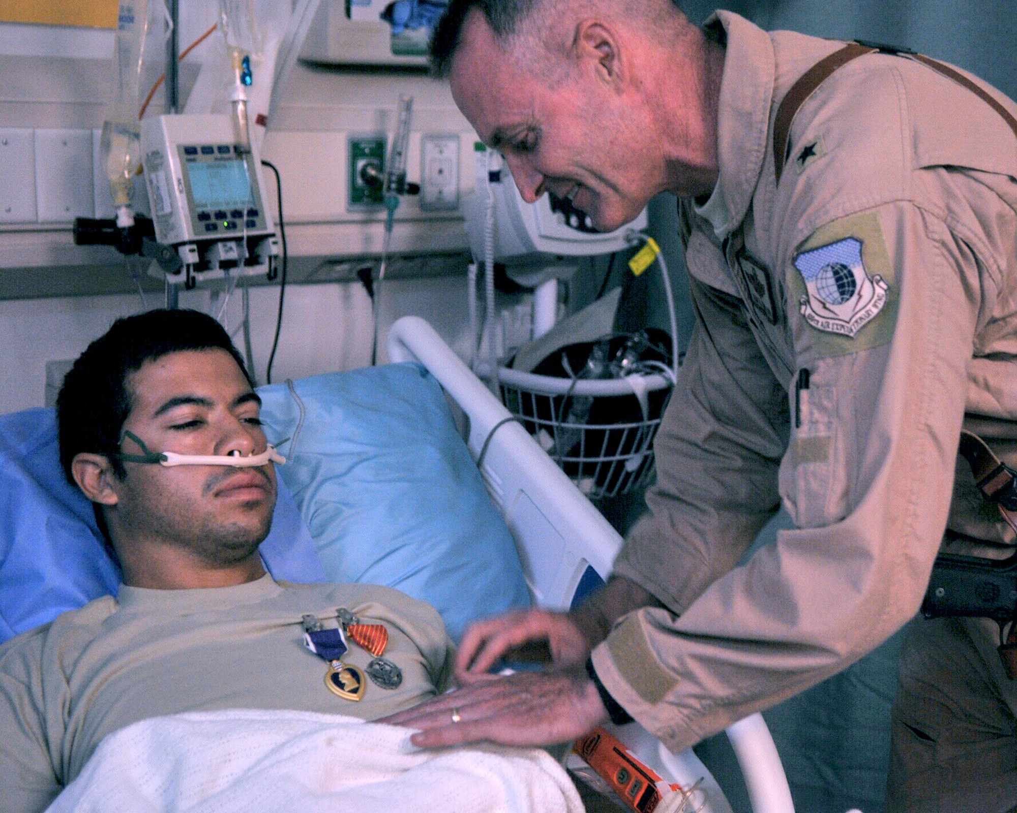BAGRAM AIRFIELD, Afghanistan -- Brig. Gen. Darryl Roberson, 455th Air Expeditionary Wing Commander, pins the Purple Heart Medal and the Air Force Combat Action Medal on Senior Airman August O’Niell, 46th Expeditionary Rescue Squadron pararescue jumper, at Craig Joint Theater Hospital July 16. O’Niell, deployed from the 58 RQS at Nellis Air Force Base, Nev., suffered gunshot wounds to his lower extremities during a mission to retrieve casualties July 15, 2011. (U.S. Air Force photo/Senior Airman Krista Rose)