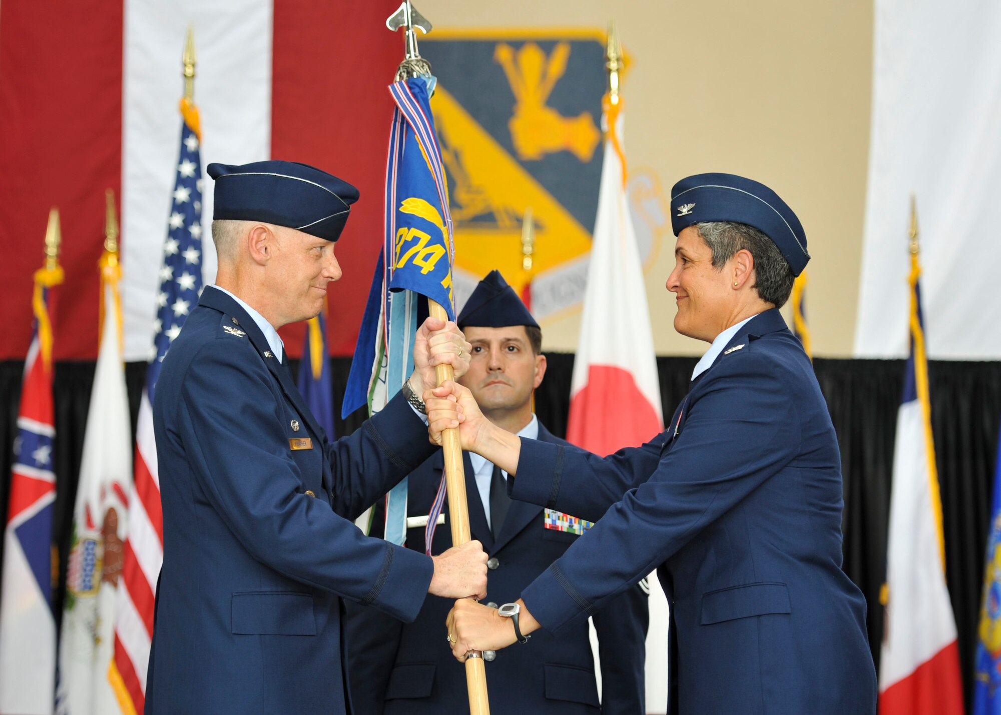 YOKOTA AIR BASE, Japan -- Col. Otto Feather (left), 374th Airlift Wing commander, passes the guidon to Col. Darlene Sanders, 374th Maintenance Group incoming commander, during the 374th MXG change of command ceremony at Yokota Air Base, Japan, July 18, 2011. The passing of the guidon symbolizes Colonel Sanders assuming command. (U.S. Air Force photo/Senior Airman Andrea Salazar)