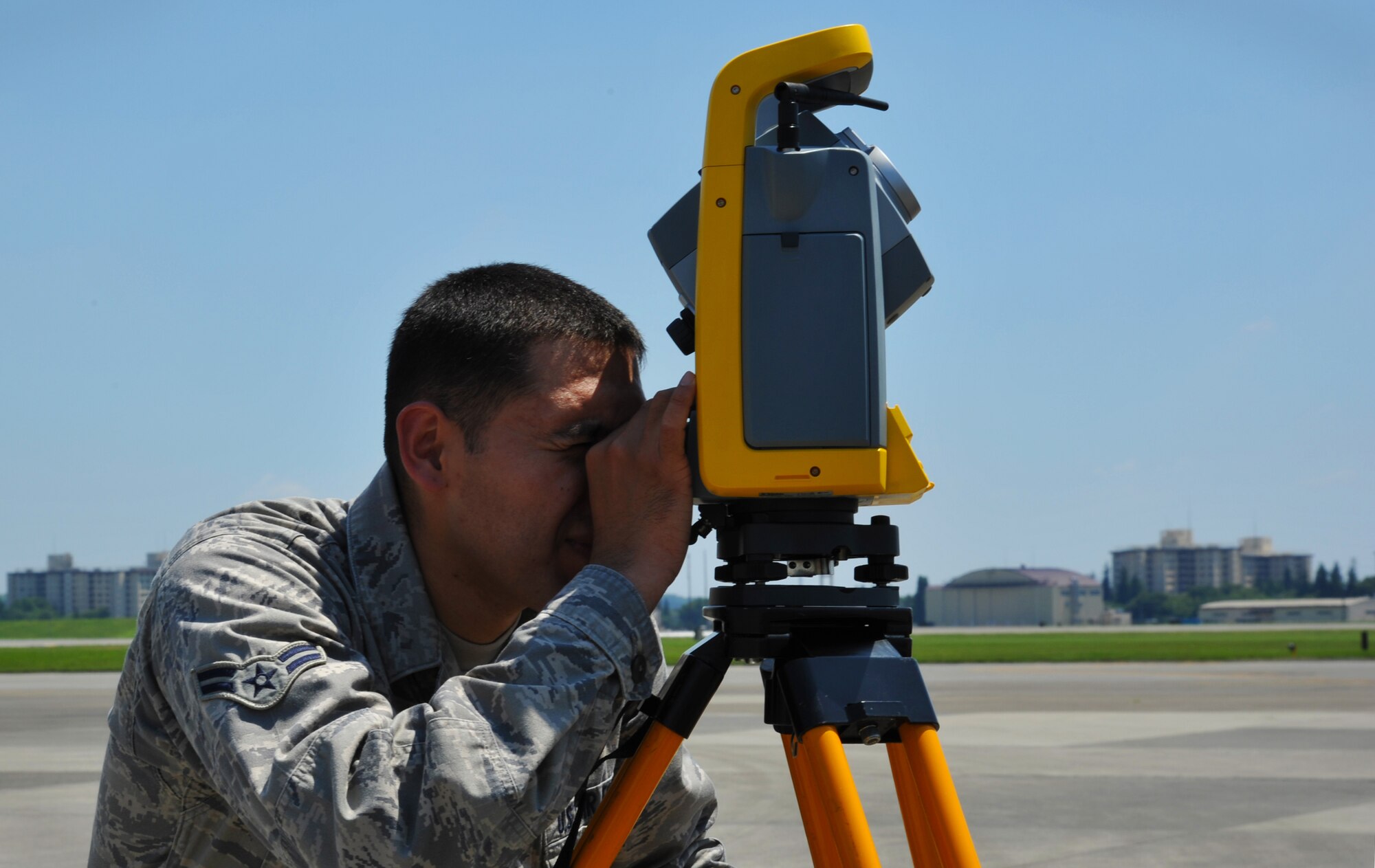 YOKOTA AIR BASE, Japan -- Airman 1st Class Carlos Ortiz, 374th Civil Engineer Squadron engineering technician, uses an optical tool to survey existing structures June 29, 2011, at Yokota Air Base, Japan. After the surveying Airman Ortiz will use the collected information to convert to the GeoBase and present the data for civil engineering projects. (U.S. Air Force photo/Senior Airman Andrea Salazar)