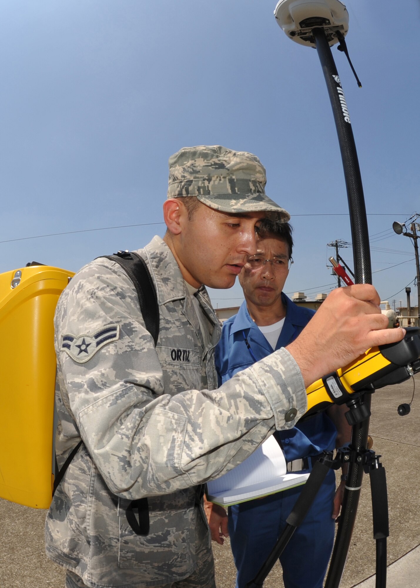 YOKOTA AIR BASE, Japan -- Airman 1st Class Carlos Ortiz (front) and Akihiko Kamijo, 374th Civil Engineer Squadron engineering technicians, conduct a site survey of a facility on Yokota Air Base, Japan, June 29, 2011. Performing site surveillances allows the 374th CES to prepare manual and computer-aided design drawings, specifications and cost estimates for projects. (U.S. Air Force photo/Senior Airman Andrea Salazar)