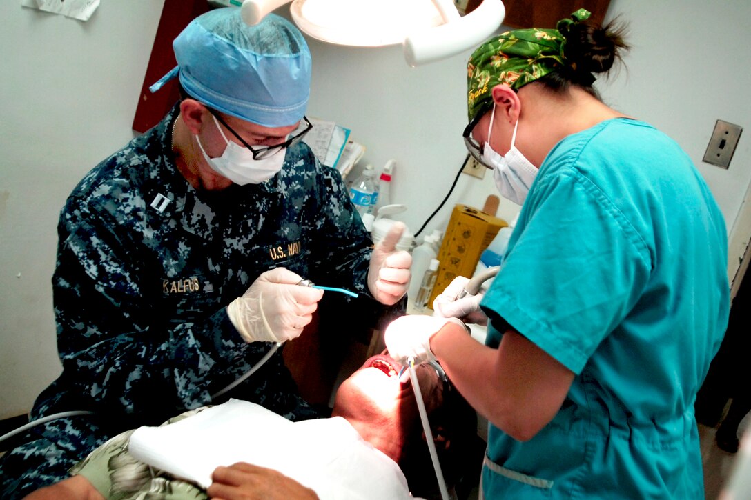 U.S. Navy Lt. (Dr.) Arthur Kalfus, left, and Petty Officer 3rd Class Celina Sweat perform dental procedures on Emanuel "Manny" Mori, the president of the Federated States of Micronesia, at the Pohnpei State Department of Health and Services medical service project site during Pacific Partnership 2011 in Pohnpei, July 12, 2011. Kalfus is a dentist and Sweat is a hospital corpsman.