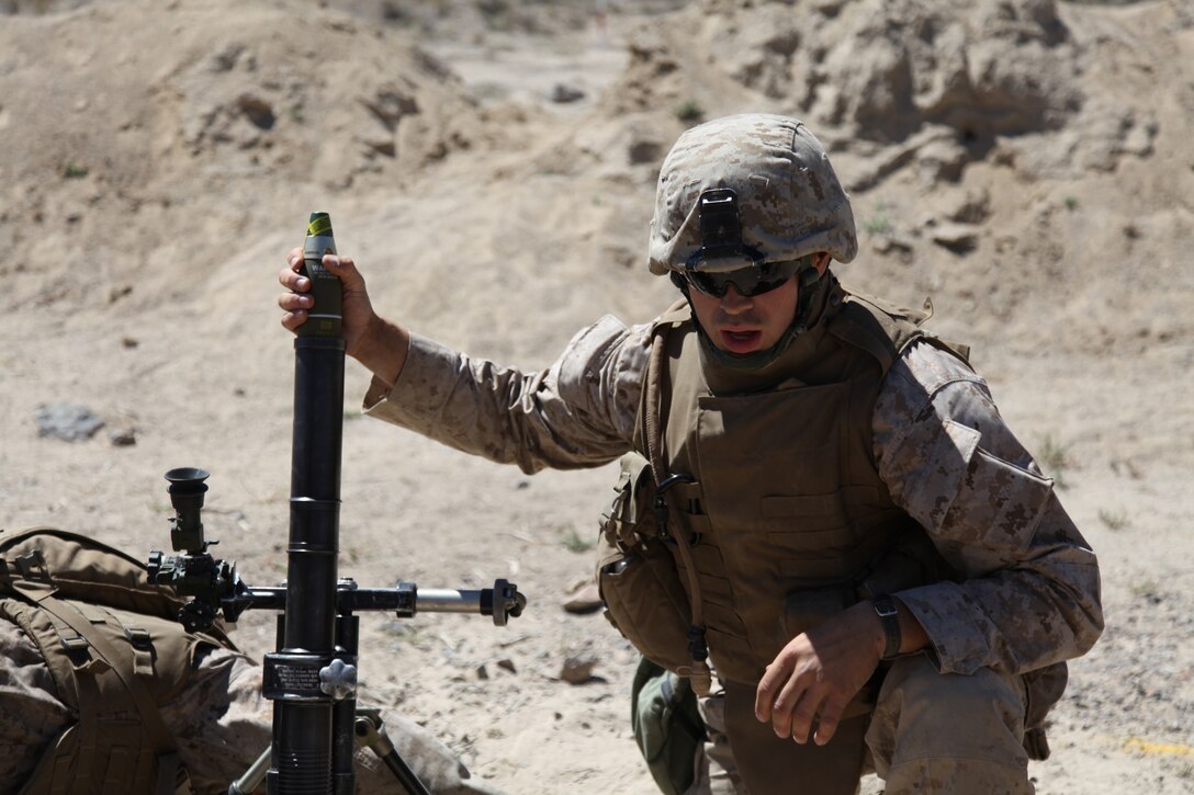 Cpl. Connor Butler, a mortarman with 2nd Battalion, 24th Marine Regiment, and Coon Rapids, Mich. native loads a 60 millimeter mortar in support of a squad maneuver, July 19. The maneuver, which combined a squad of riflemen, mortars and machine gun section, reinforced basic war fighting skills while focusing on communication and engaging the enemy in difficult terrain.