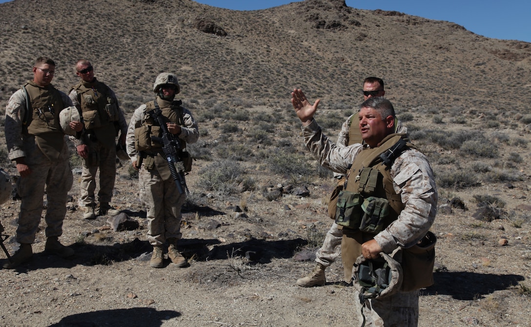 Chief Warrant Officer 4 Charles Major, the Battalion Gunner for 2nd Battalion, 24th Marine Regiment debriefs the Marines after a squad maneuver, June 19. After the movement, the Marines received feedback on their performance, allowing them to improve and build upon lessons learned.