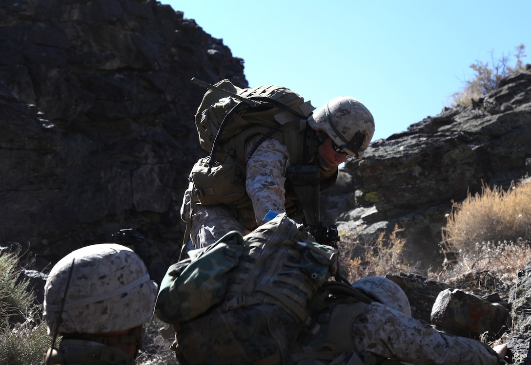Marines with Company E, 2nd Battalion, 24th Marine Regiment, help each other climb the washout during a squad maneuver, June 19. The rocky incline was one of the most challenging parts of the maneuver.