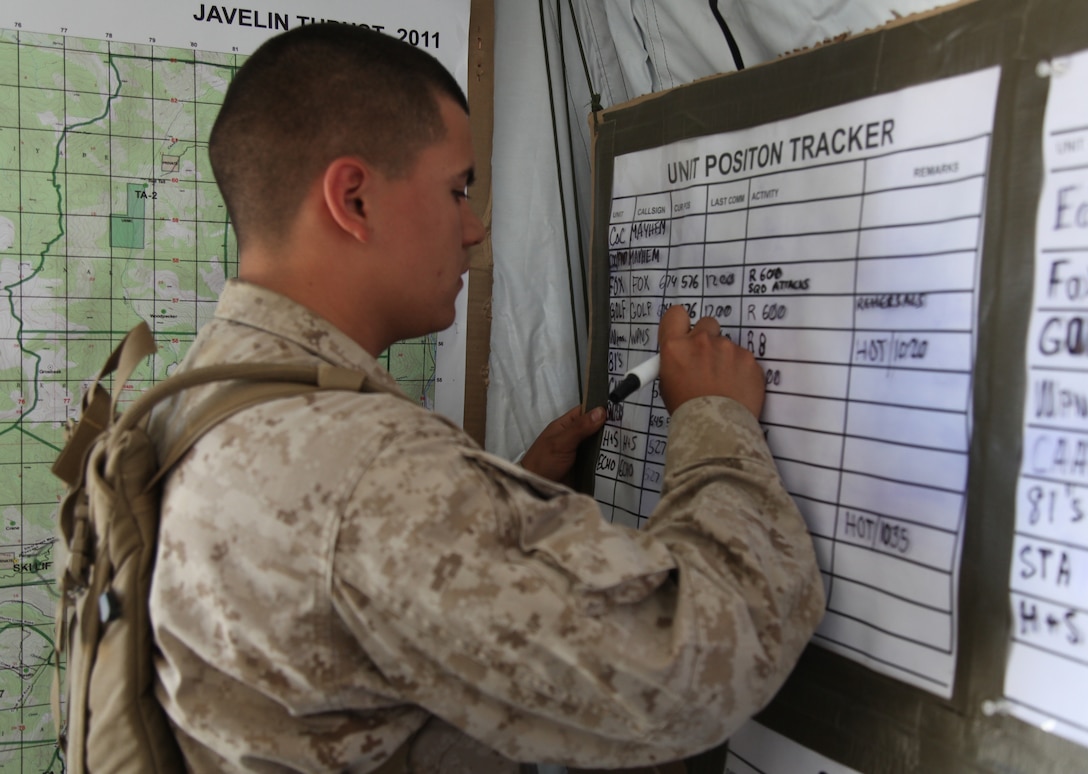 Lance Cpl. Pablo Pena, a rifleman with 2nd Battalion, 24th Marine Regiment and Chicago native, marks unit positions in the 2/24 Combat Operations Center, July 19. One of the COC’s primary missions is to maintain accountability of all units under its command.