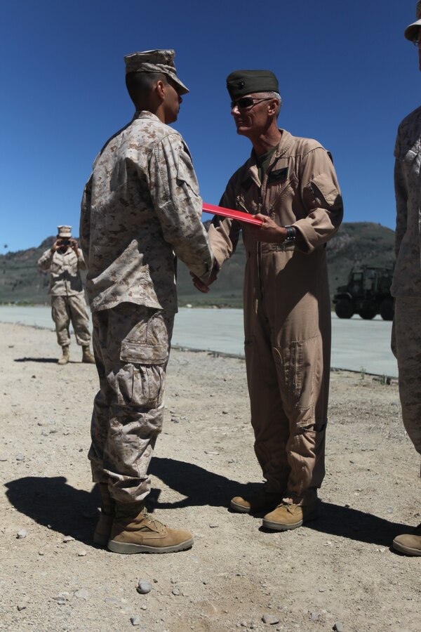 Maj. Gen. Rex C. McMillian, the commanding general of 4th Marine Aircraft Wing, hands Cpl. Philimon Nasry, a radio operator with Marine Wing Communication Squadron 48, his promotion warrant during a promotion ceremony at Marine Corps Mountain Warfare Training Center July 19. "He told me to keep up the good work, train my Marines to succeed and to hold onto my lance corporal chevrons to motivate a younger Marine," Nasry said.