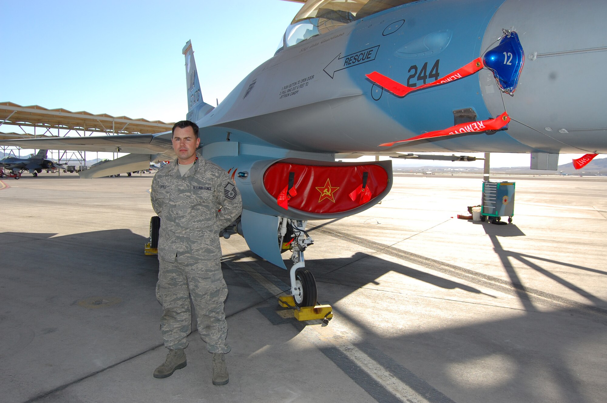 NELLIS AIR FORCE BASE, Nev. -- Master Sgt. Seth Little, 926th Aircraft Maintenance Squadron flightline expediter, stands by an F-16 aggressor aircraft on the flightline here. Sergeant Little is a reservist integrated into a Regular Air Force unit, helping to maintain Nellis' fleet of F-16 jets on a daily basis. (U.S. Air Force photo/Capt. Jessica Martin)