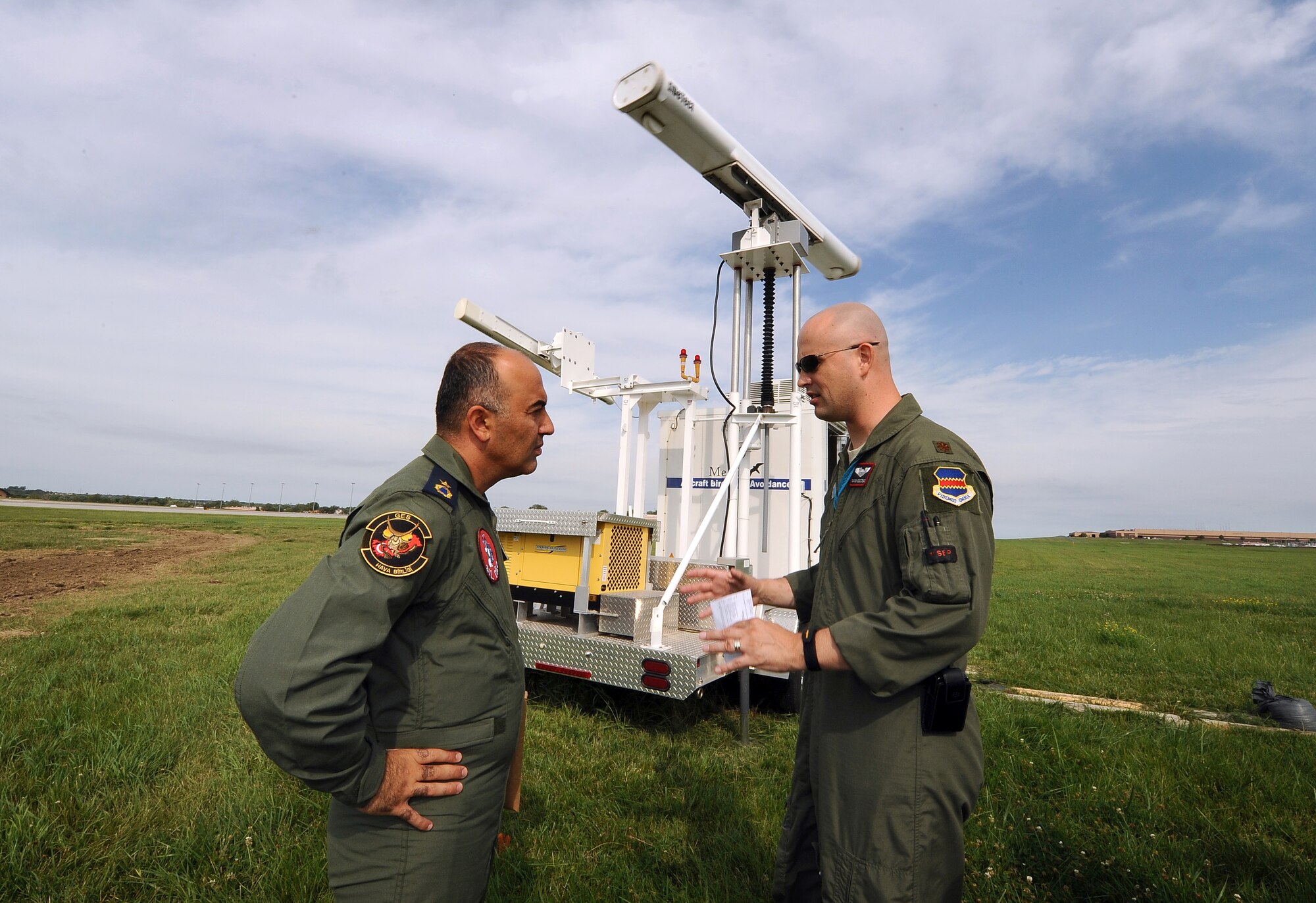 Turkish Air Force Maj. Bulent Cankaya (left) gets information from Maj. Gavin Gigstead, 55th Wing chief of flight safety, regarding the MERLIN Avian Radar Warning System at Offutt July 12. The radar system protects incoming and outgoing aircraft from local bird populations that can cause significant damage if they are sucked into an aircrafts engine.  (U.S. Air Force photo by Josh Plueger/Released)
