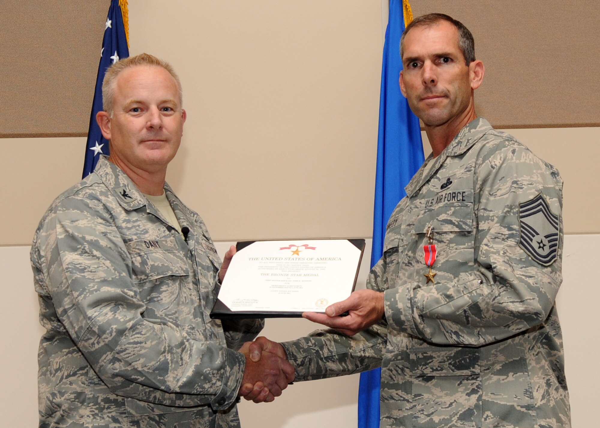 BUCKLEY AIR FORCE BASE, Colo. --  Colonel Daniel Dant, 460th Space Wing commander, awards the Bronze Star to Chief Master Sgt. Todd Kennedy, 460th Communications Squadron July 15, 2011. Kennedy received the Bronze Star for leading his troops in a combat environment. His exceptional leadership and battlefield presence were crucial to the squadron's mission capability as well as the integrated execution of joint and coalition counter-insurgency operations. (U.S. Air Force photo by Airman1st Class Marcy Glass)
