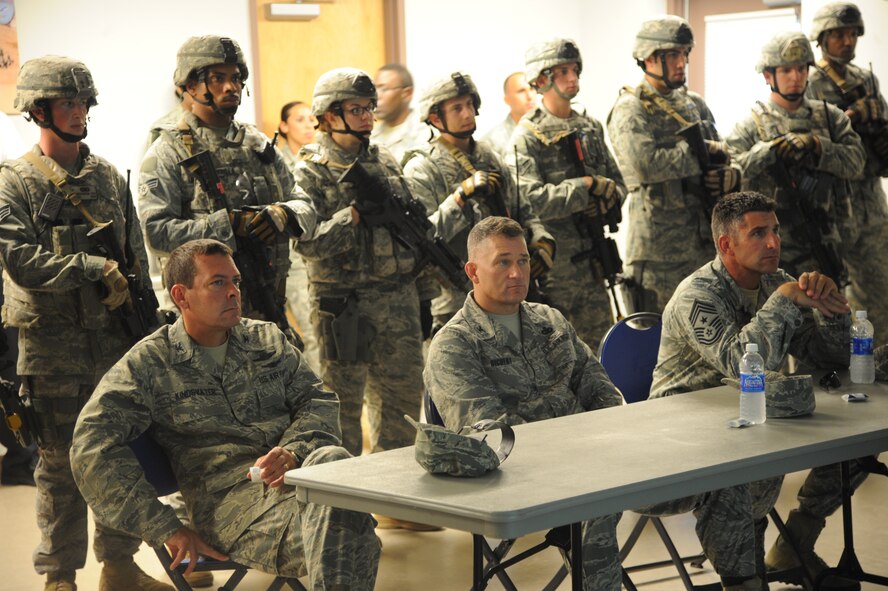 U.S. Air Force Col. Scott Kindsvater, 93rd Air Ground Operations Wing commander (left), Col. Randall Richert, 820th Base Defense Group commander (center), and Chief Master Sgt. Atticus Smith, 93rd AGOW command chief, listen in during a briefing at Moody Air Force Base, Ga., July 20, 2011. The brief covered the specifics of how Airmen would operate during a military operations in urban terrain demo. (U.S. Air Force photo by Airman 1st Class Paul Francis/Released)