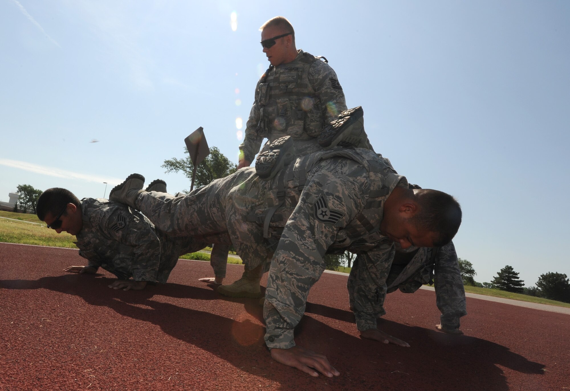 Tech. Sergeant Ryan Overcash, 22nd Security Forces Squadron RODEO team leader, stands in the middle of the 22nd SFS RODEO team as a “four-man” push-up is executed July 15, 2011, McConnell Air Force Base, Kan.  The team has been training for three months for the RODEO competition at Joint Base Lewis-McChord, Wash., July 24 to 29, 2011.  (Air Force photo/ Airman 1st Class Laura L. Valentine)