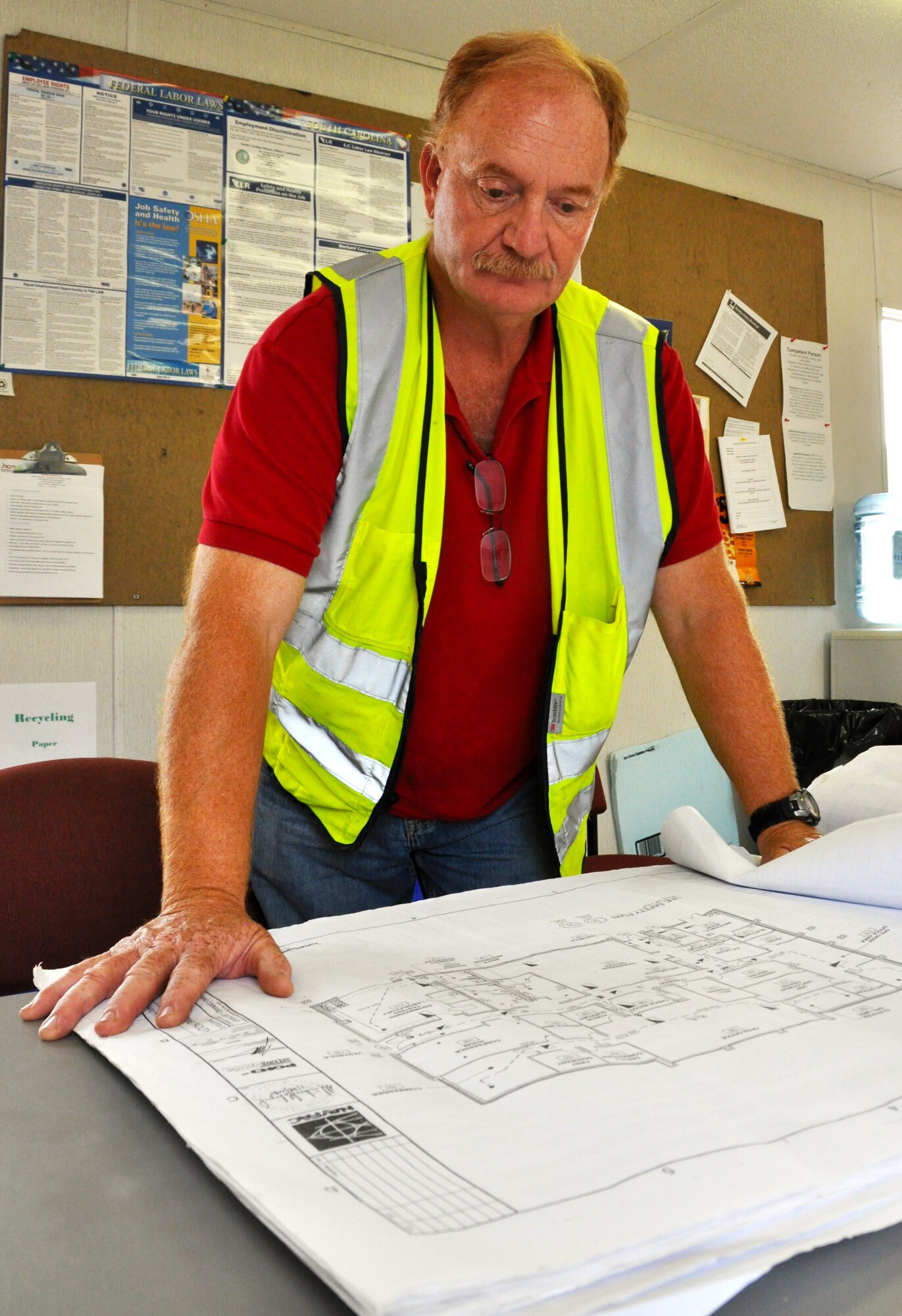 David Keber, construction superintendent on the Red Horse project, reviews the plans for the squadron's new buildings. The civilian construction company plans to make the new structure more environmentally friendly and energy efficient. (Air Force Photo)
