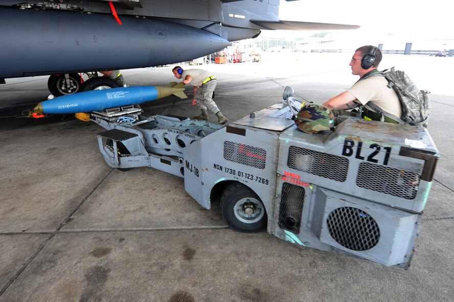 SEYMOUR JOHNSON AIR FORCE BASE, N.C. – Staff Sgt. Tim Smith rotates an inert BDU-50 on a jammer, a motorized cart used to carry munitions from the transport vehicle to the aircraft, driven by Senior Airman Daniel Farris for loading onto an F-15E Strike Eagle during a Phase II operational readiness exercise (ORE) here July 20, 2011. A Phase II ORE tests the ability of Airmen to operate and react to scenarios that are common in deployed locations. Smith, 336th Aircraft Maintenance Squadron team chief, is a native of Carlisle, Pa., and Farris, 336th AMXS weapons technician, is a native of Jerome, Pa.(U.S. Air Force photo by Senior Airman Rae Perry/RELEASED) 