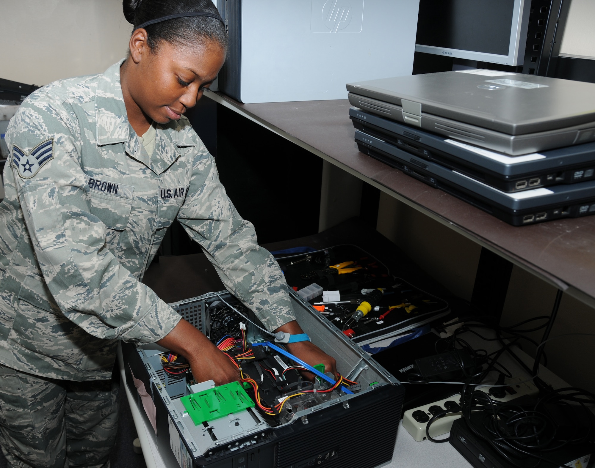 Senior Airman Chelsey Brown, 81st Communications Squadron client systems technician, troubleshoots a problem with a computer by checking cable connections inside the central processing unit.  (U.S. Air Force photo by Kemberly Groue)