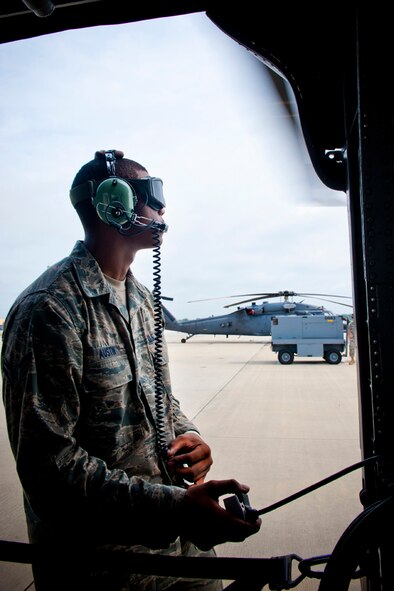 U.S. Air Force Airman 1st Class Clinton Austin, 723rd Aircraft Maintenance Squadron crew chief, communicates with a flying crew while preparing an HH-60G Pave Hawk for flight at Moody Air Force Base, Ga., July 12, 2011. Direct communication between maintainers and flight crew members is needed incase anything goes wrong during pre-flight checks. (U.S. Air Force photo by Staff Sgt. Jamal D. Sutter/Released)