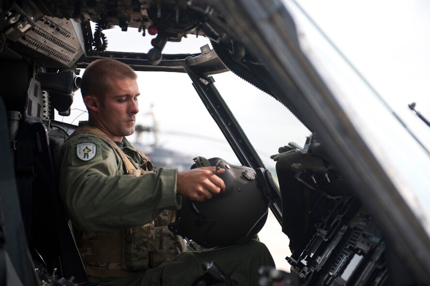U.S. Air Force 1st Lt. Will Theisner, 41st Rescue Squadron HH-60 co-pilot, equips his gear in preparation for a training mission at Moody Air Force Base, Ga., July 12, 2011. During the mission, Theisner flew the aircraft alongside Lt. Col. Jeremey Turner, 41st RQS commander. (U.S. Air Force photo by Staff Sgt. Jamal D. Sutter/Released)