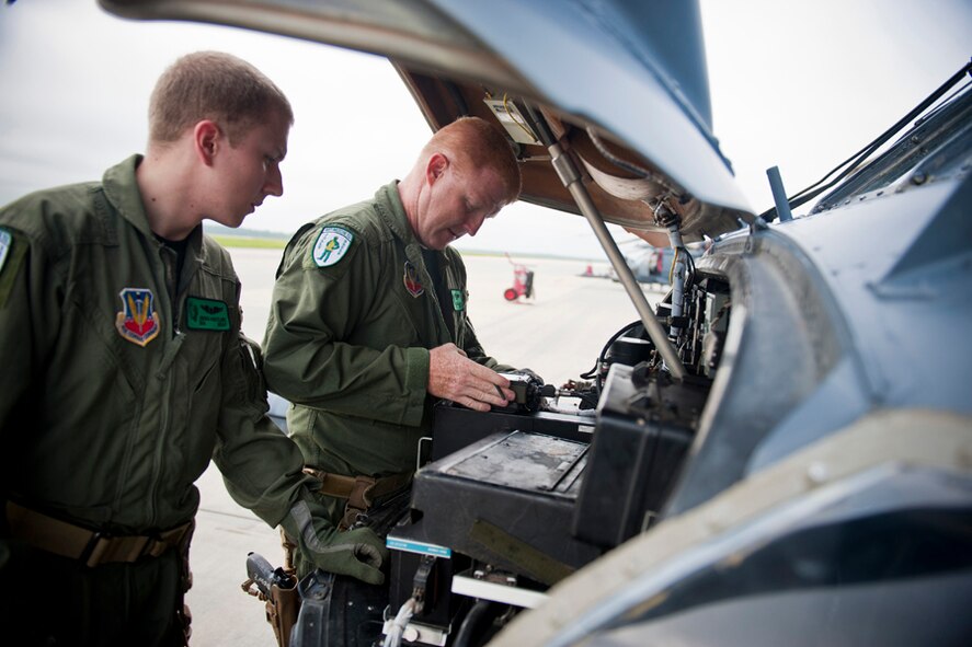 U.S. Air Force Senior Airman Josiah Hartline (left) and Chief Master Sgt. Scott Callahan, 41st Rescue Squadron aerial gunners, conduct radio installations to an HH-60G Pave Hawk at Moody Air Force Base, Ga., July 12, 2011. The installation ensured communication between the flight crew and key operations agencies during the training mission. (U.S. Air Force photo by Staff Sgt. Jamal D. Sutter/Released)