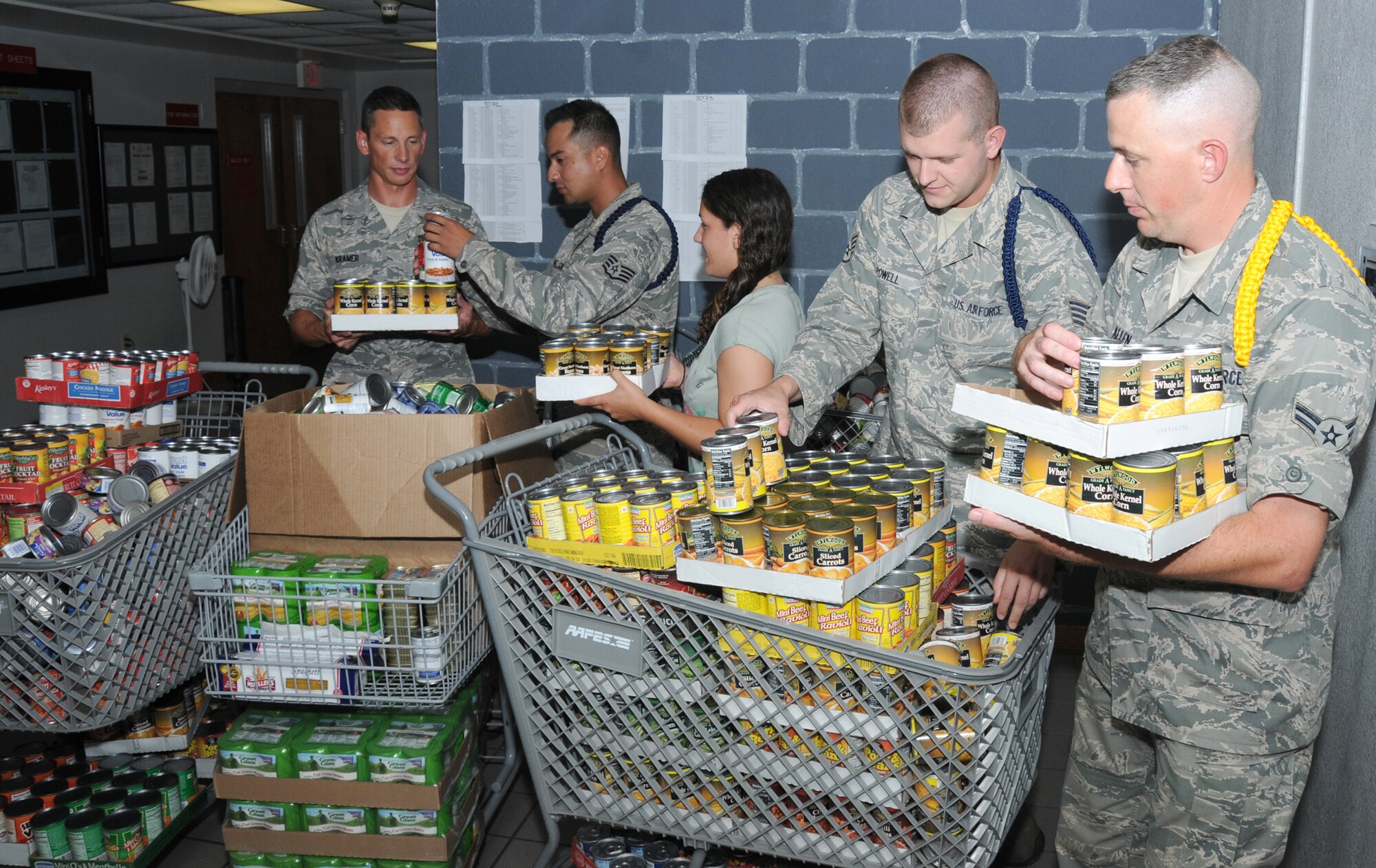 From left, Airman 1st Class Jason Kramer, Staff Sgt. Leonardo Nelson, Airman 1st Class Brittany Simmons, Staff Sgt. Anthony Powell and Airman 1st Class Allen
Thomas, 338th Training Squadron, sort and stock canned goods at Winters Manor. Kramer, Simmons and Thomas are students and Nelson and Powell are military training leaders. The Dark Knights donated 2,058 cans of food and money to buy groceries to be delivered to local food pantries that serve the needy.  (U.S. Air Force photo by Kemberly Groue)