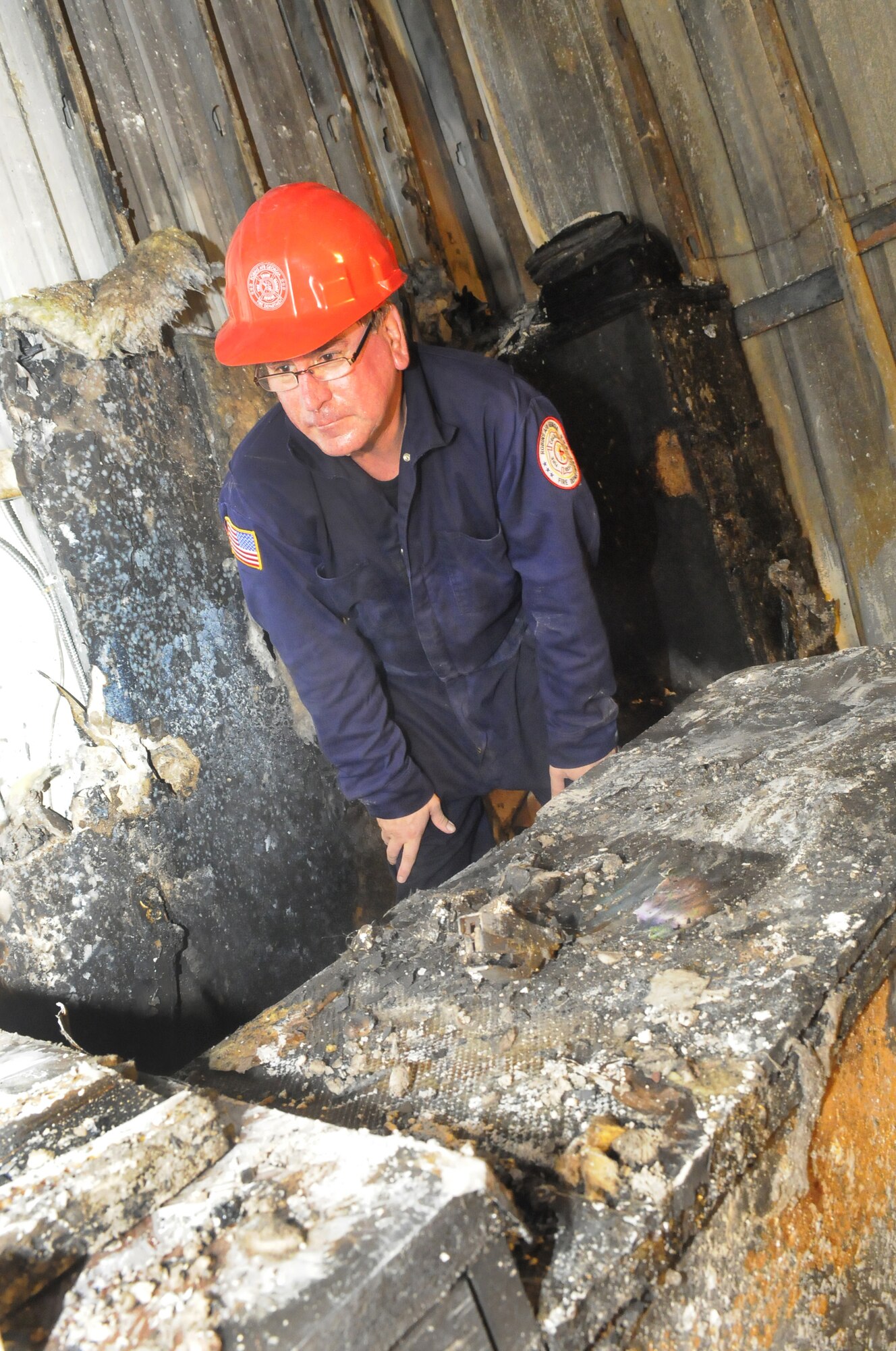 Tom Kennedy, assistant fire chief, Fire Prevention and Investigations, looks over fire damage in Bldg. 352 during his investigation. U. S. Air Force photo by Sue Sapp