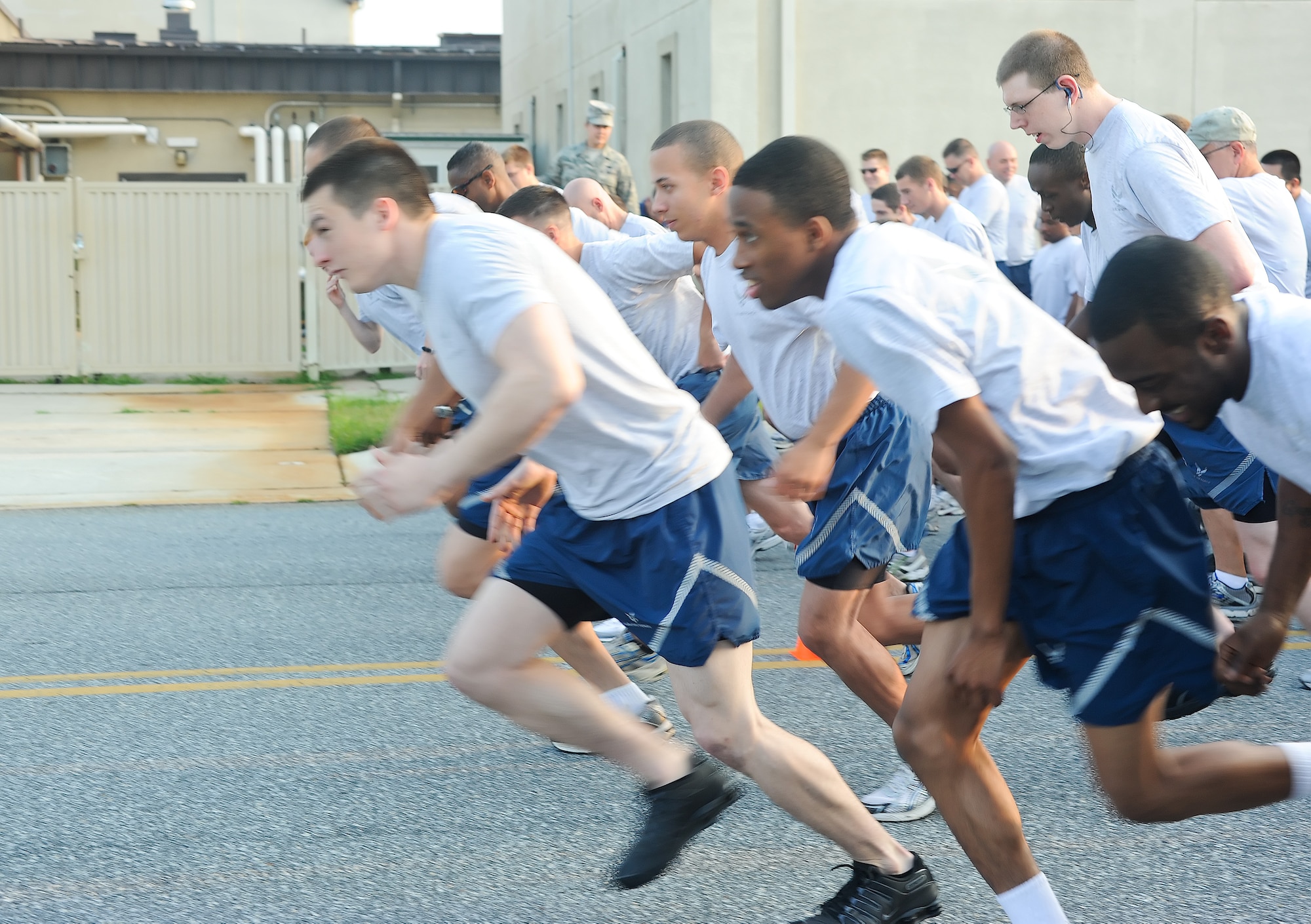 Airmen sprint off the starting line during the Warrior Run July 20, 2011, at Dover Air Force Base, Del. Dozens of Airmen participated in the five-kilometer run, which are held monthly to build morale and emphasize fitness.  (U.S. Air Force photo by Airman 1st Class Samuel Taylor)