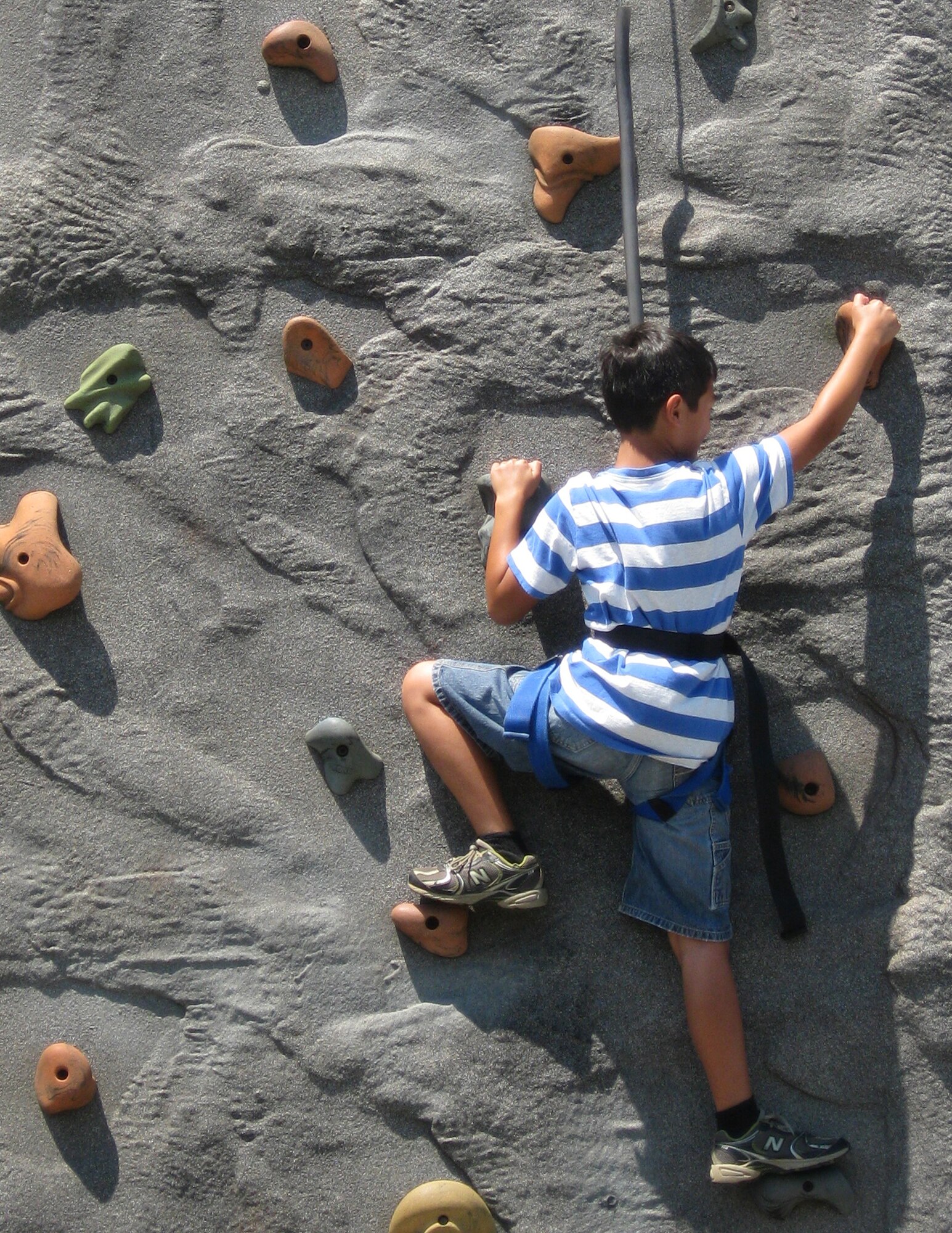 GRISSOM AIR RESERVE BASE, Ind. -- A child maneuvers his way up the rock wall during Grissom's annual Family Appreciation Day held on the July  unit training assembly.  Games and activities were just part of the event this year with an information fair, car show and other events also taking place. (U.S. Air Force photo/Tech. Sgt. Douglas Hays)