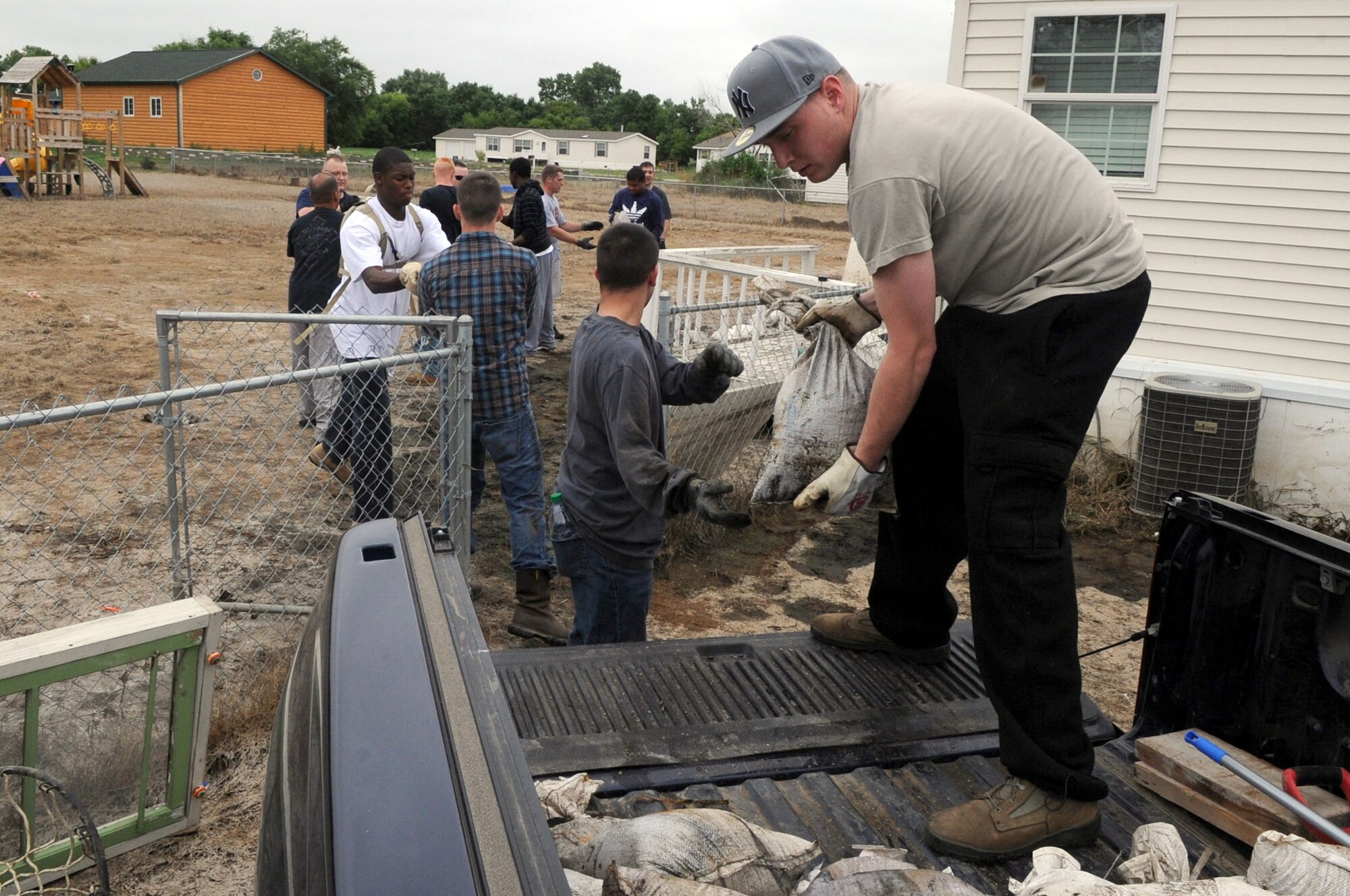 MINOT AIR FORCE BASE, N.D. -- Airman 1st Class Ryan Hellman, 791st Missile Security Forces Squadron team member, helps stack sandbags onto a vehicle July 14. Hellman, along with fellow team members, came together to help Tech. Sgt. Lance Berentson, 741st Missile Squadron facility manager and Airman affected by the recent flood situation, begin the restoration of his home in Minot. (U.S. Air Force photo/Airman 1st Class Jose L. Hernandez) 
