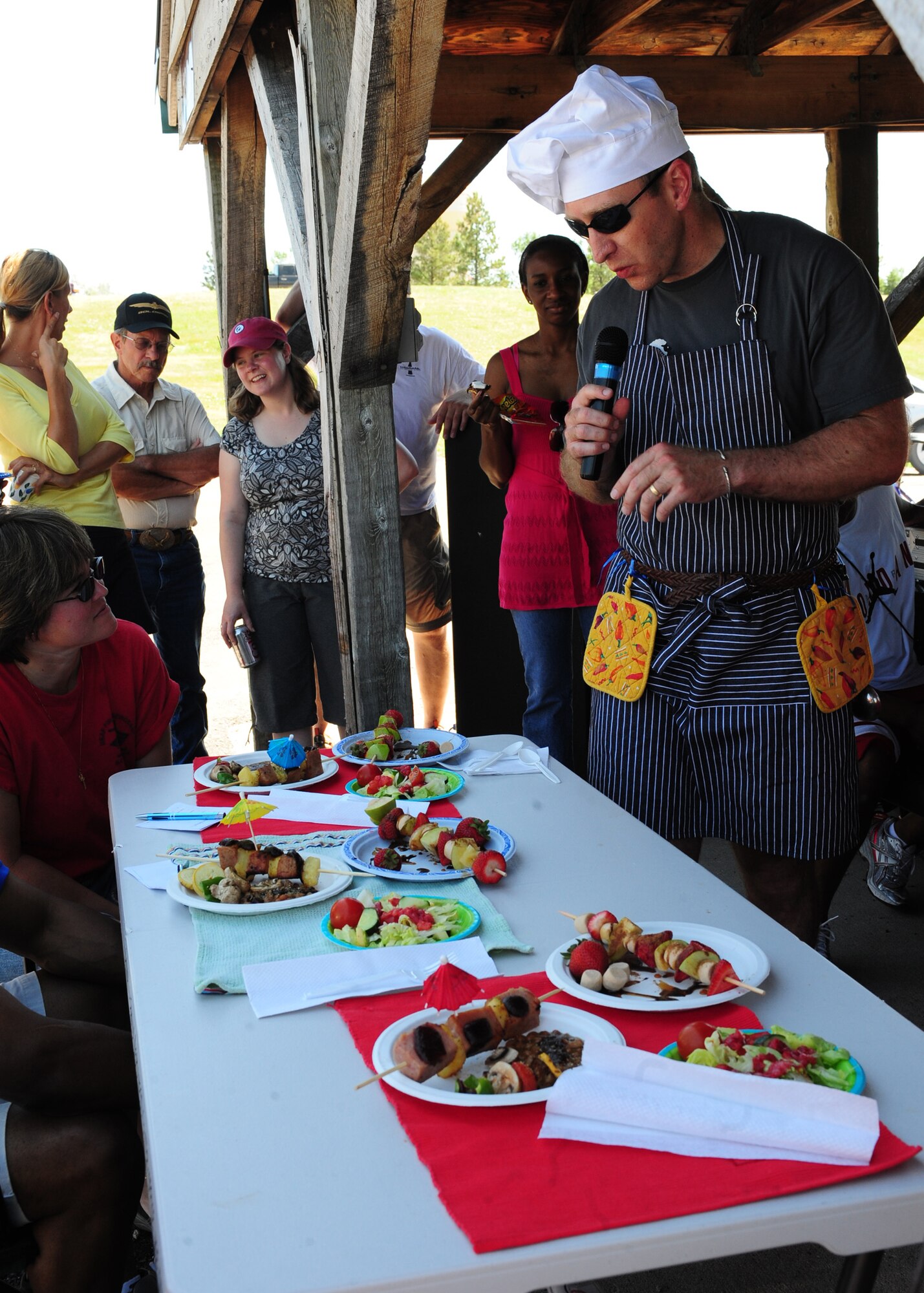 Maj. Bryan Kemper, 28th Medical Group chief of optometry, presents his team’s dish to the Ultimate Challenge II: Dine N’ Dash judges at Ellsworth Air Force Base, S.D., July 16, 2011. After a long course on an extremely hot day, the teams had to prepare a dish for the judges as part of the event. (U.S. Air Force photo/Airman Alystria Maurer/Released)