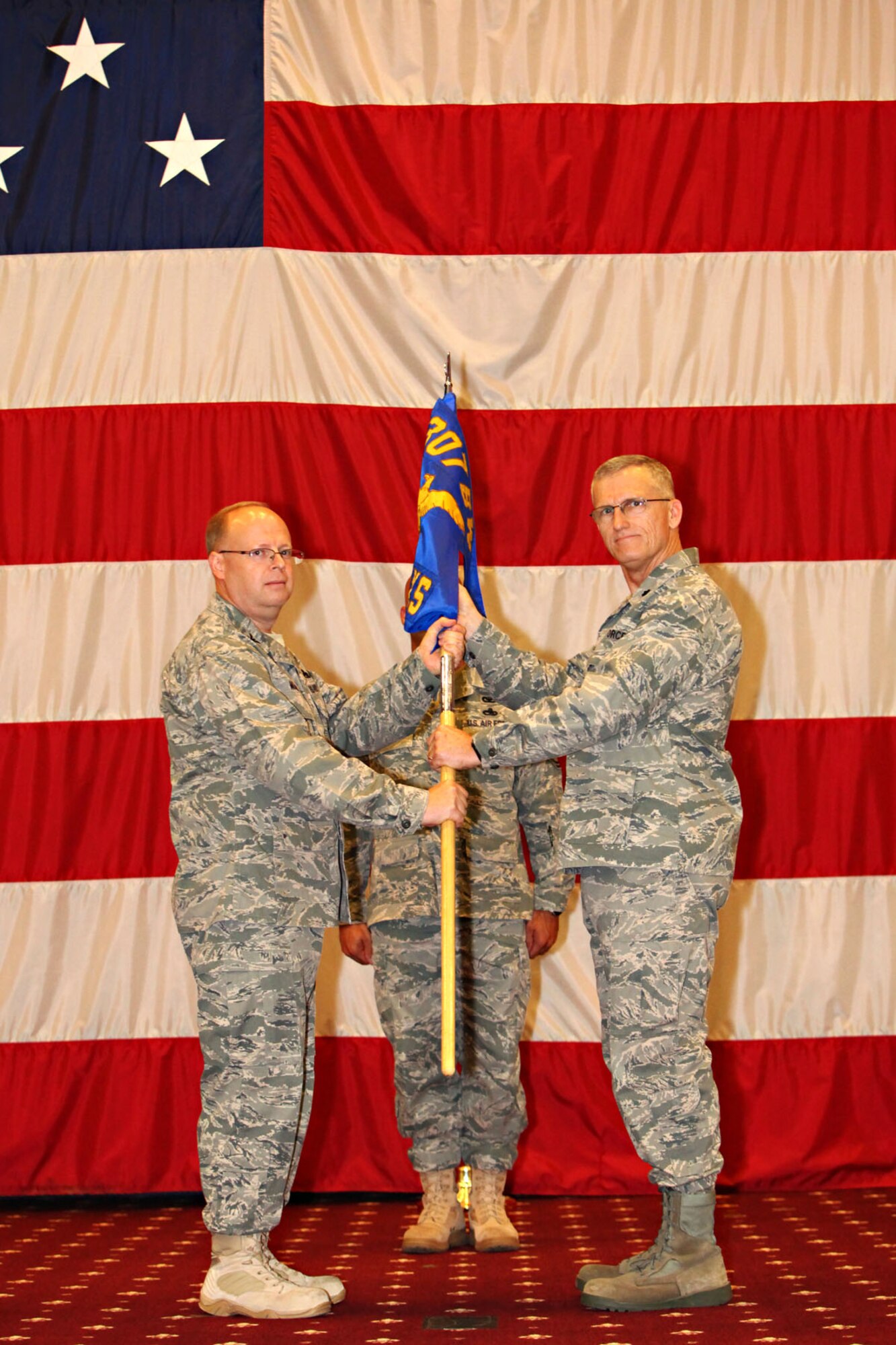 Col. Jeffrey S. Mullen, the commander of the 307th Maintenance Group, presents the 707th Maintenance Squadron guidon to Lt. Col. Dwayne W. Slack, in Hoban Hall during ceremonies standing up the 707th MXS at Barksdale Air Force Base, La., Jan. 8, 2011. The new Reserve squadron is a “classic association” maintenance squadron for the 2nd Bomb Wing. The 2nd BW, which is an active duty Air Force wing, owns the aircraft, while the 707th MXS supplies people to help maintain and support them. Colonel Slack is the first to command the new squadron. Presently the 707th MXS has 74 people in the unit. When it is totally manned, it will have approximately 200 personnel assigned, 71 Air Reserve Technicians (fulltime) and 129 (part-time) Reservists Traditional. (U.S. Air Force photo/Senior Master Sgt. Mahmoud Rasouliyan)

