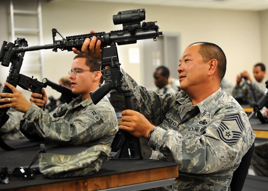 U.S. Air Force Chief Master Sgt. Scott Fujimoto, 20th Logistics Readiness Squadron superintendent, takes apart his M4 carbine during the Combat Arms Training and Maintenance class here at the small arms training range July 19, 2011. Airmen take the CATM class as a requirement for deployments, Permanent Change of Station, or training. (U.S. Air Force photo/Airman 1st Class Tabatha L. Duarte) (Released) 