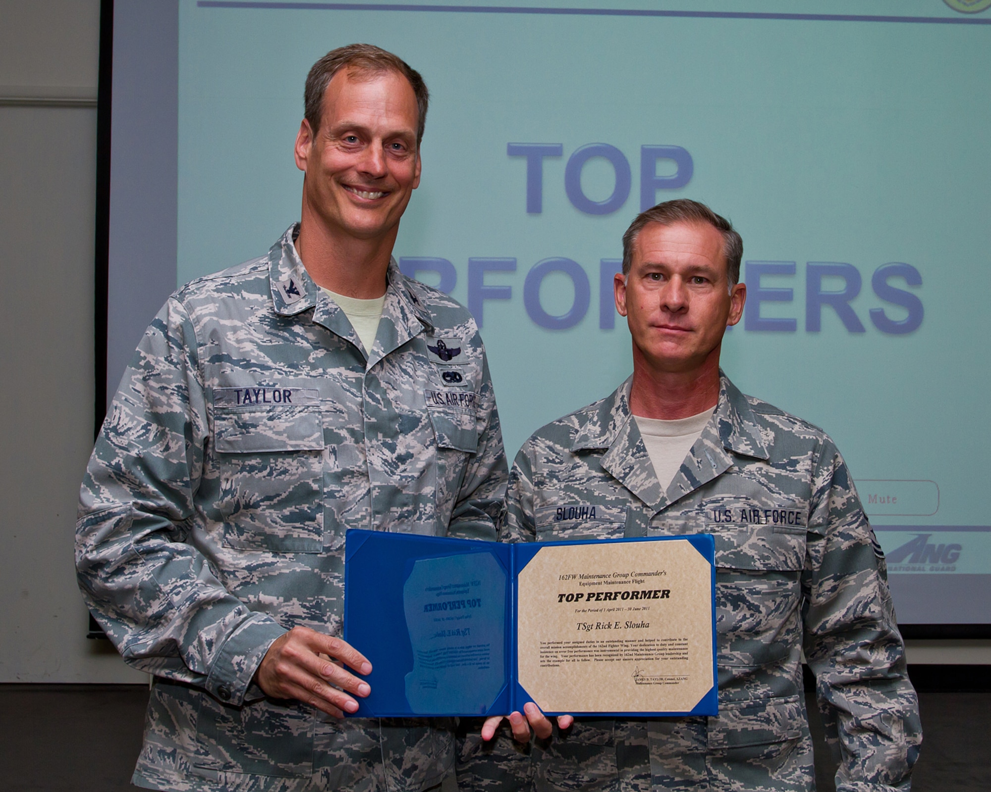 Col. James Taylor (left) presents Tech. Sgt. Rick Slouha the Top Performers Award for his work with the Equipment Maintenance Flight. (U.S. Air Force photo/Senior Airman Chris Heising)