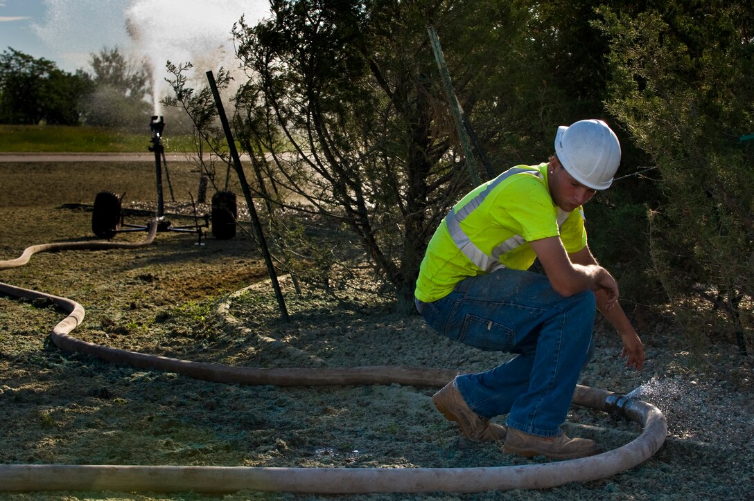 Clayton King, Shamrock Enterprise laborer, sets up a water sprinkler July 20, 2011 at Ellsworth AFB, S.D. Shamrock has been subcontracted to Xeriscape 17 high profile areas around the base, which will save the Air Force, and taxpayers, more than $113,000 a year. (U.S. Air Force photo/Tech. Sgt. Nathan Gallahan/Released)