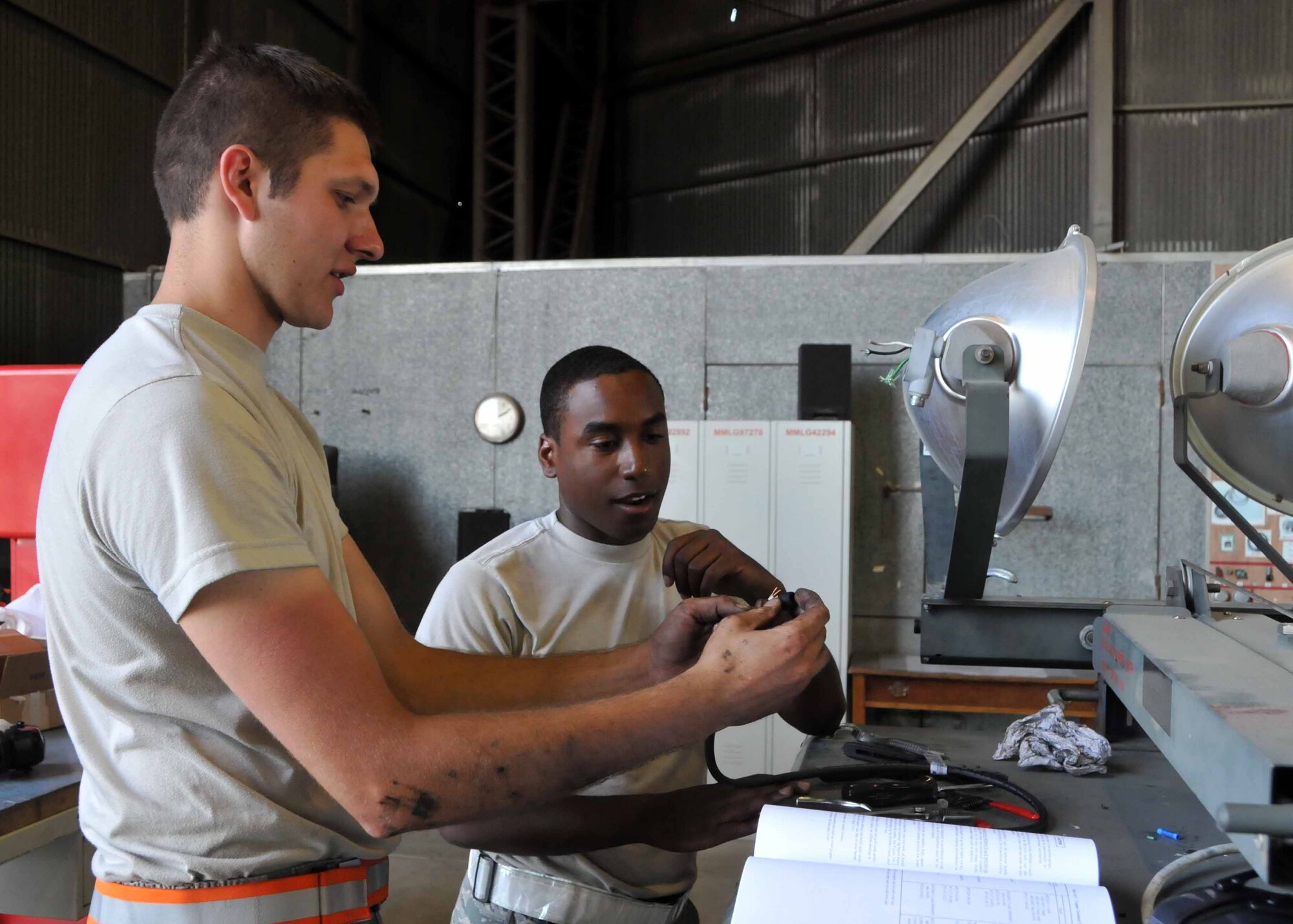 Staff Sgt. Jesse D. Albrecht offers Airman 1st Class Christopher L. Petty some On-the-Job-Training while performing routine maintenance on a light cart while deployed in Western Europe at the 313th Air Expeditionary Wing on July 19, 2011. (U.S. Air Force phot/Capt. John P. Capra)