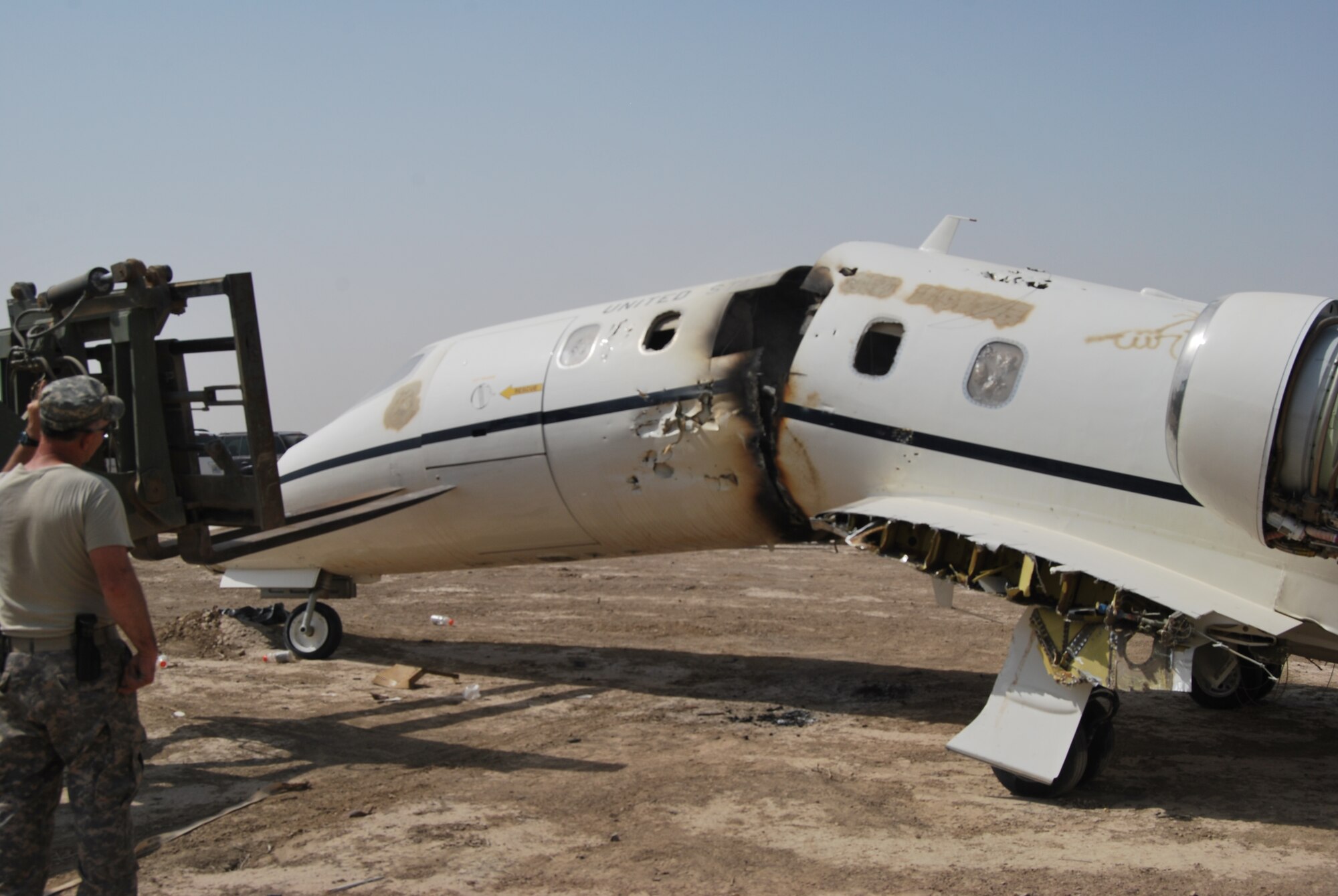 The fuselage of a U.S. Air Force C-21 transport plane is broke into pieces using a forklift, prior to its final destruction on 15 July.  The aircraft made a hard langing in 2009, was deemed irreparable, and is being demilitarized and disposed.  (Air Force photo by Capt. Jeffrey Davis)