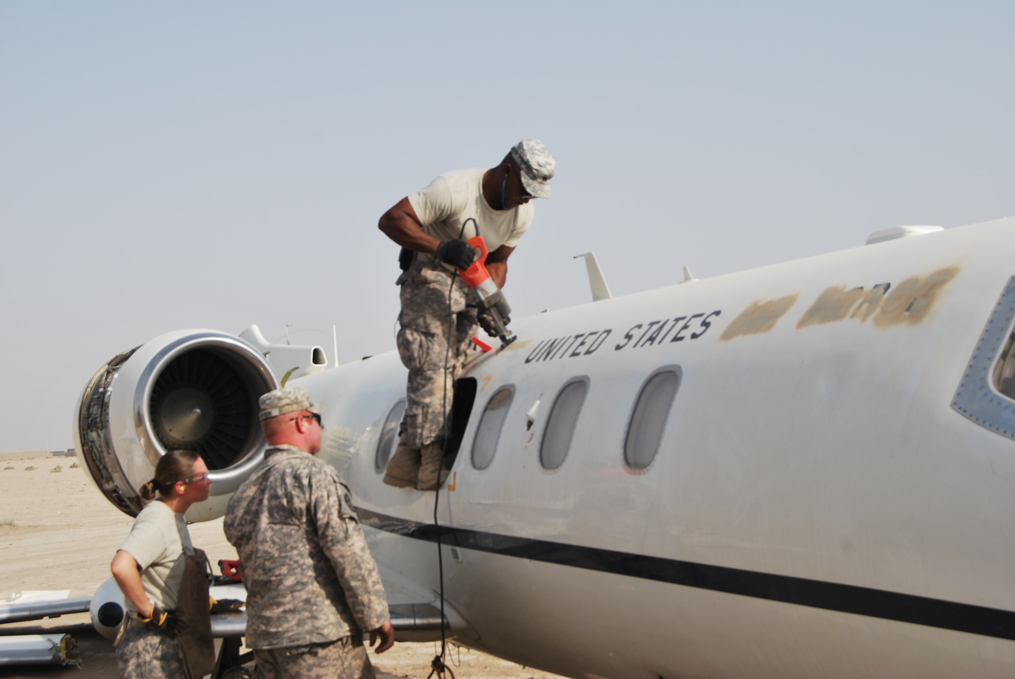 Sgt. Ronald Brown, a machinist with the 1729th Forward Support Maintenance Company, 749th Combat Sustainment Support Battalion, 4th Sustainment Brigade, 310th Expeditionary Sustainment Command, and an Aberdeen Proving Grounds, Md., native, saws at a C-21 transportation jet during a downed aircraft recovery team training exercise on Contingency Operating Base Adder, Iraq, July 15. (Air Force Photo by Capt. Jeffrey Davis)