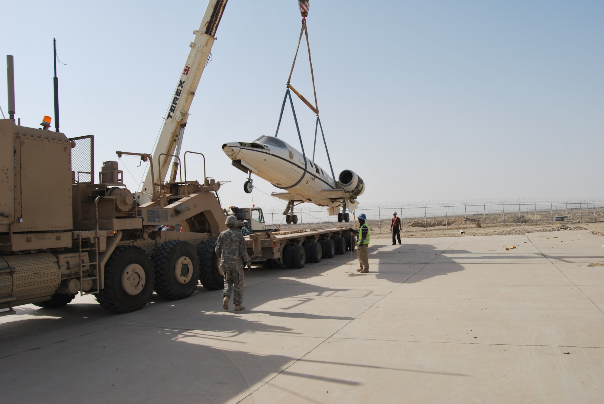 A damaged C-21 U.S. Air Force aircraft is secured for movement by soldiers from the  68th Transportation Company, 749th Combat Sustainment Support Battalion, 4th Sustainment Brigade, 310th Expeditionary Sustainment Command, during a training exercise on Contingency Operating Base Adder, Iraq, July 5. (U.S. Air Force photo by Capt. Jeffrey Davis)