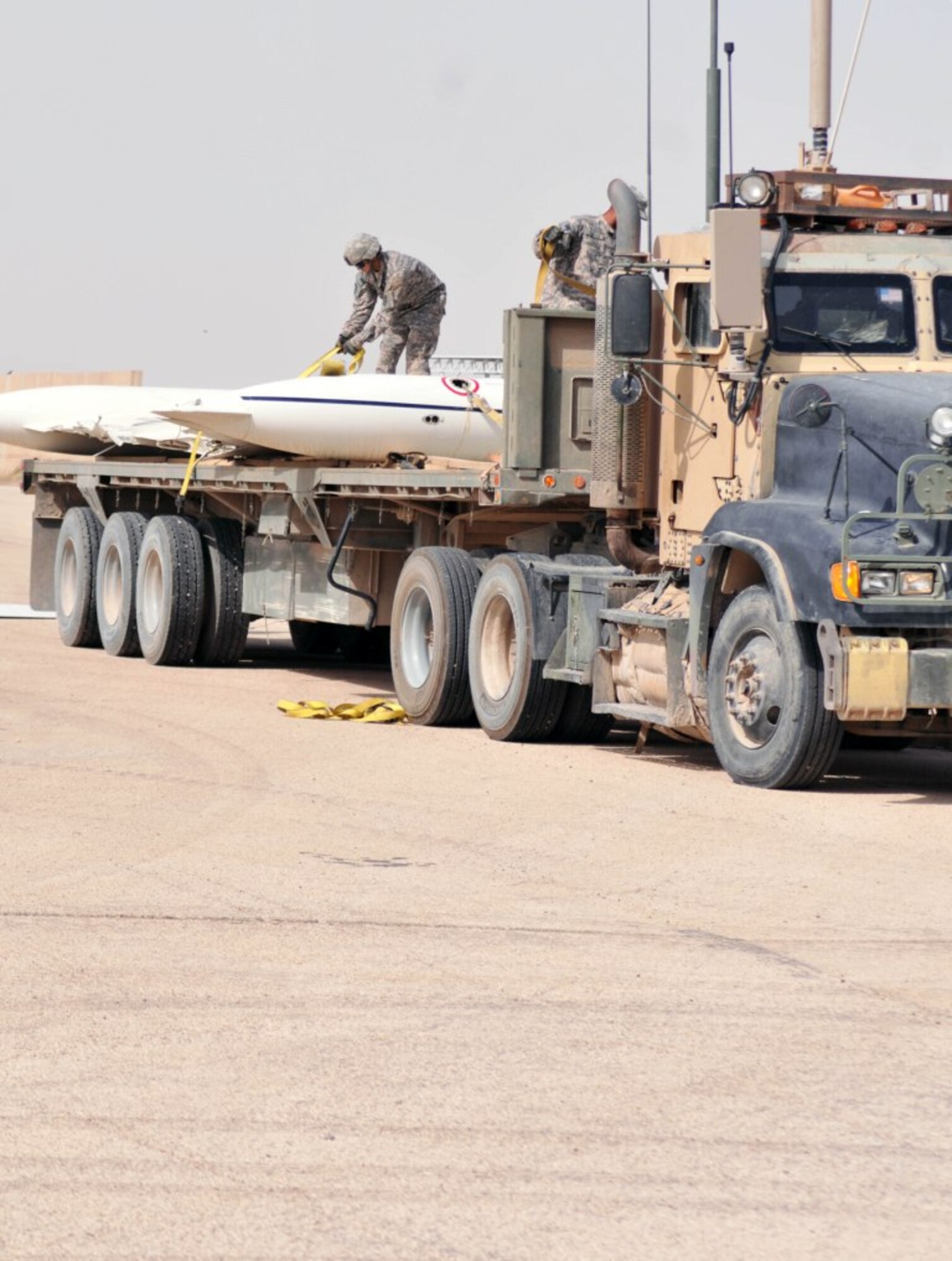 Soldiers with the 749th Combat Sustainment Support Battalion secure parts of a damaged U.S. Air Force C-21 transport aircraft, bound for its final destruction, onto a vehicle during a training exercise on Contingency Operating Base Adder, Iraq, July 5. (U.S. Army photo by Pfc. Amy M. Lane)