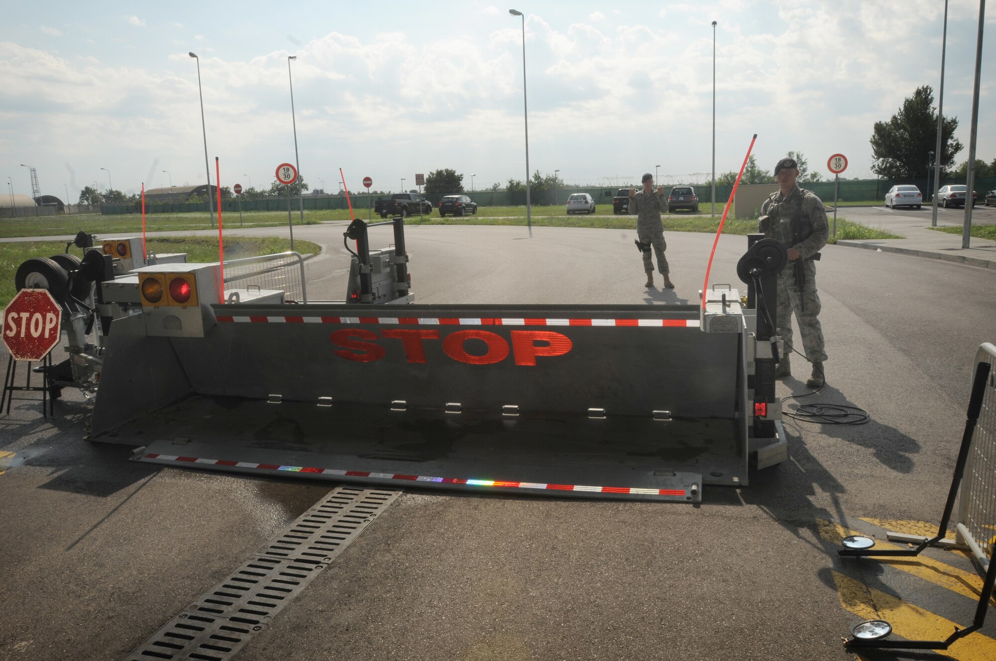 Airmen 1st Class Johnie Prentice and William Lott, 31st Security Forces Squadron contractor inspection team members, guide a contractor’s vehicle July 15 at Aviano Air Base’s larger vehicle inspection station gate. The inspection team searches 75 vehicles per day.(U.S. Air Force photo/Airman LaVel Sterling)