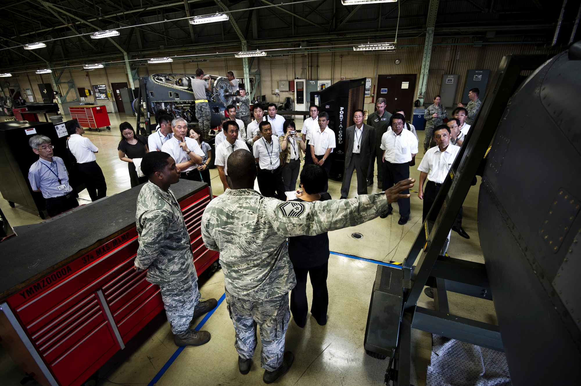 YOKOTA AIR BASE, Japan -- Senior Master Sgt. David Keller (front center), 374th Maintenance Squadron Propulsion Flight chief, and 2nd Lt. Steven Clark, 374th MXS Propulsion Flight commander, give a tour of their work center to visiting local dignitaries at Yokota Air Base, Japan, July 19, 2011. Each quarter, Yokota hosts vice mayors from the six surrounding communities as well as leaders from the Tokyo Metropolitan Government, North Kanto Defense Bureau and Yokota Defense Office to discuss local concerns and strengthen ties between the base and its neighbors. (U.S. Air Force photo/Staff Sgt. Samuel Morse)